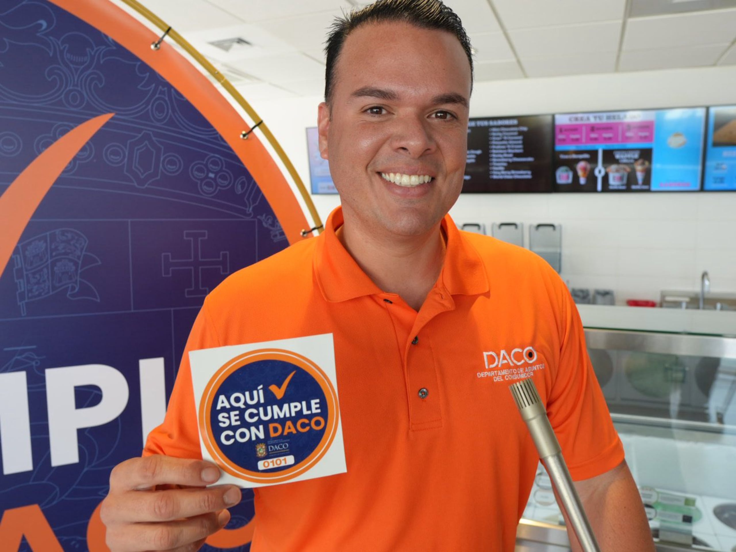 El secretario del DACO, Hiram Torres Montalvo, muestra el sello con el que identificarán a los comercios.