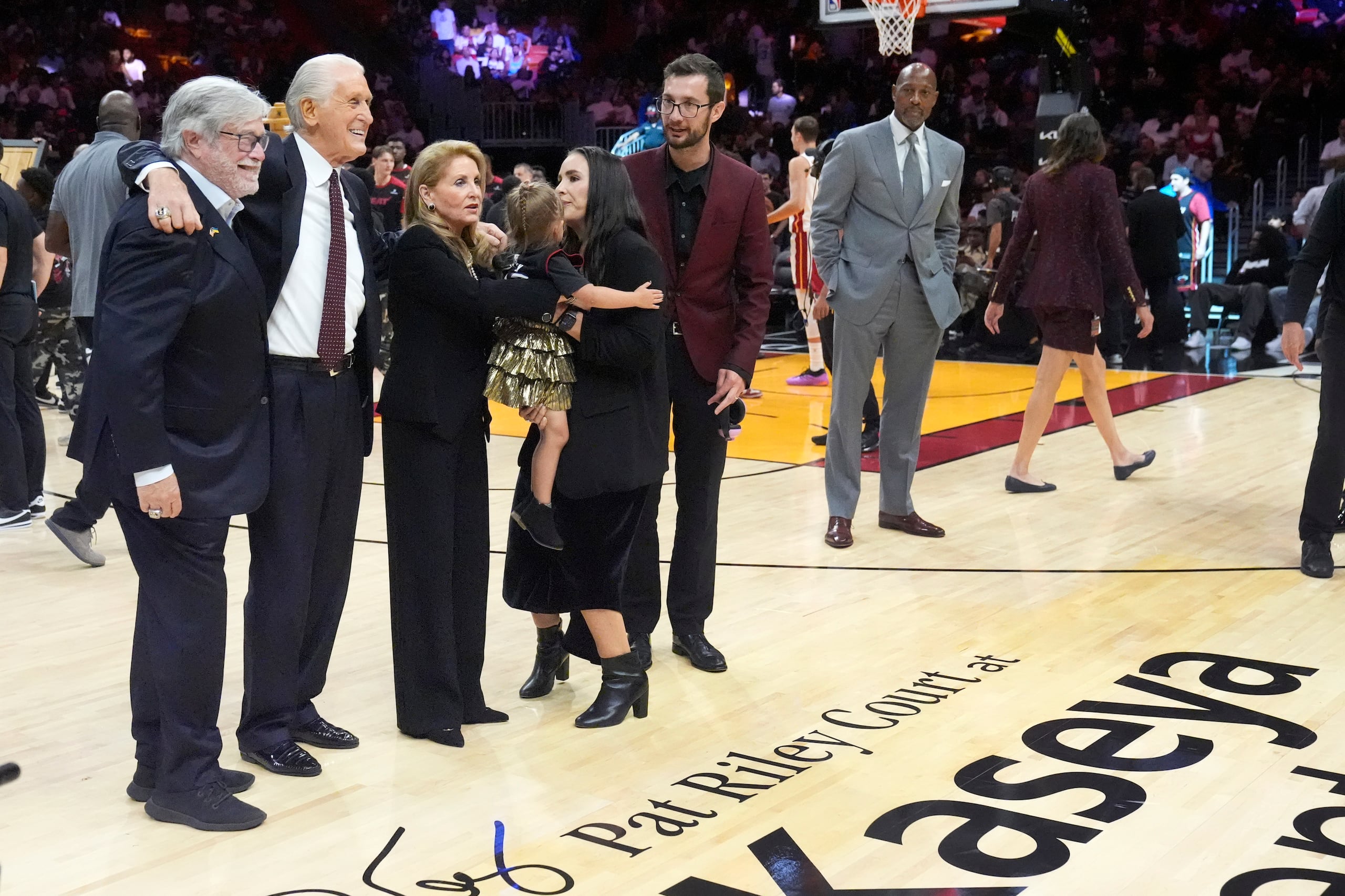De izquierda a derecha, el socio director general del Heat de Miami, Micky Arison; el presidente del equipo Pat Riley y la familia de este último participan en una ceremonia el miércoles 23 de octubre de 2024. La cancha del Heat fue bautizada con el nombre de Riley.