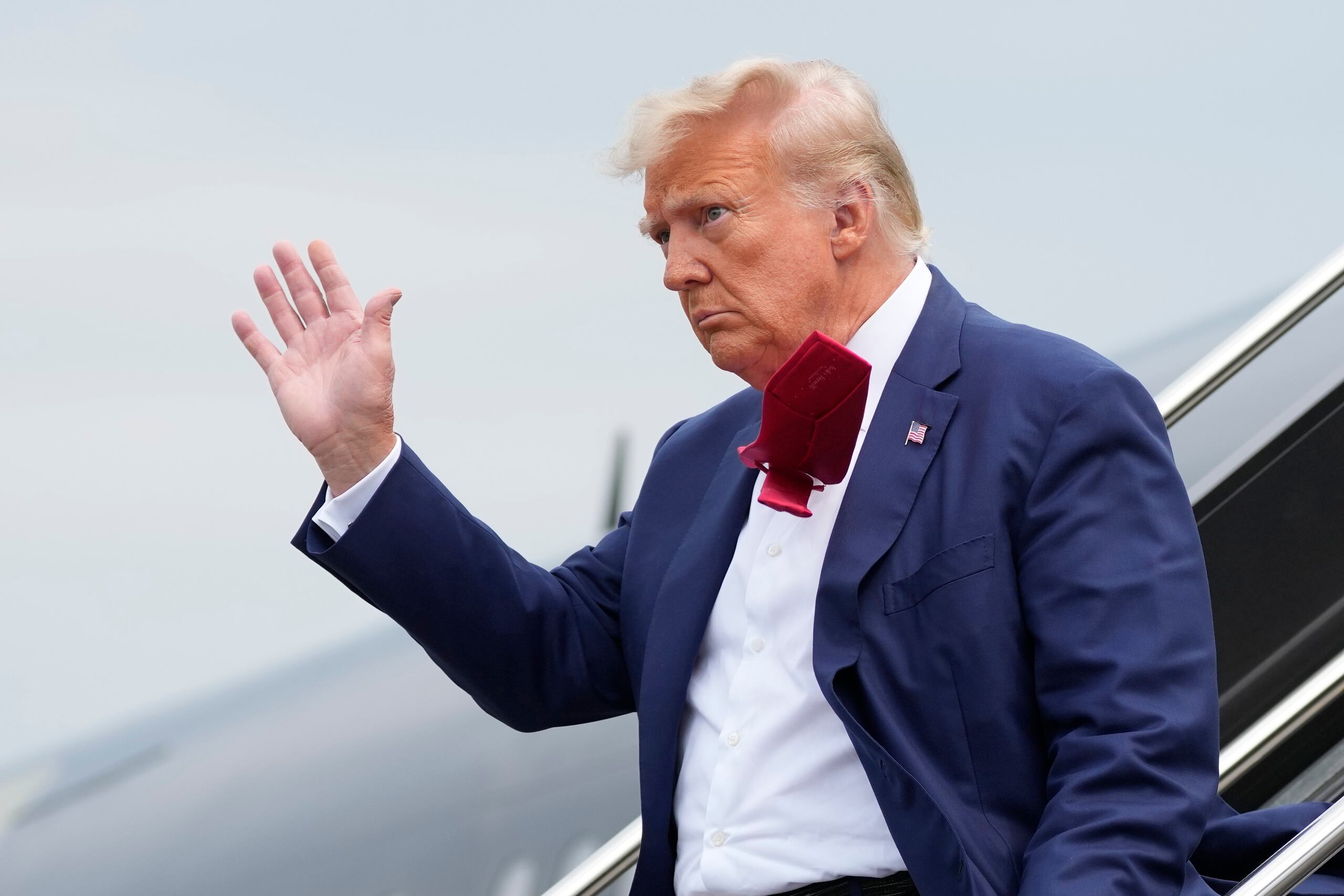 El expresidente Donald Trump saluda a los presentes mientras se baja de su avión en el Aeropuerto Nacional Ronald Reagan de Washington en su camino a enfrentar un juez por acusaciones federales de conspirar para revertir las elecciones 2020. (AP Photo/Alex Brandon)