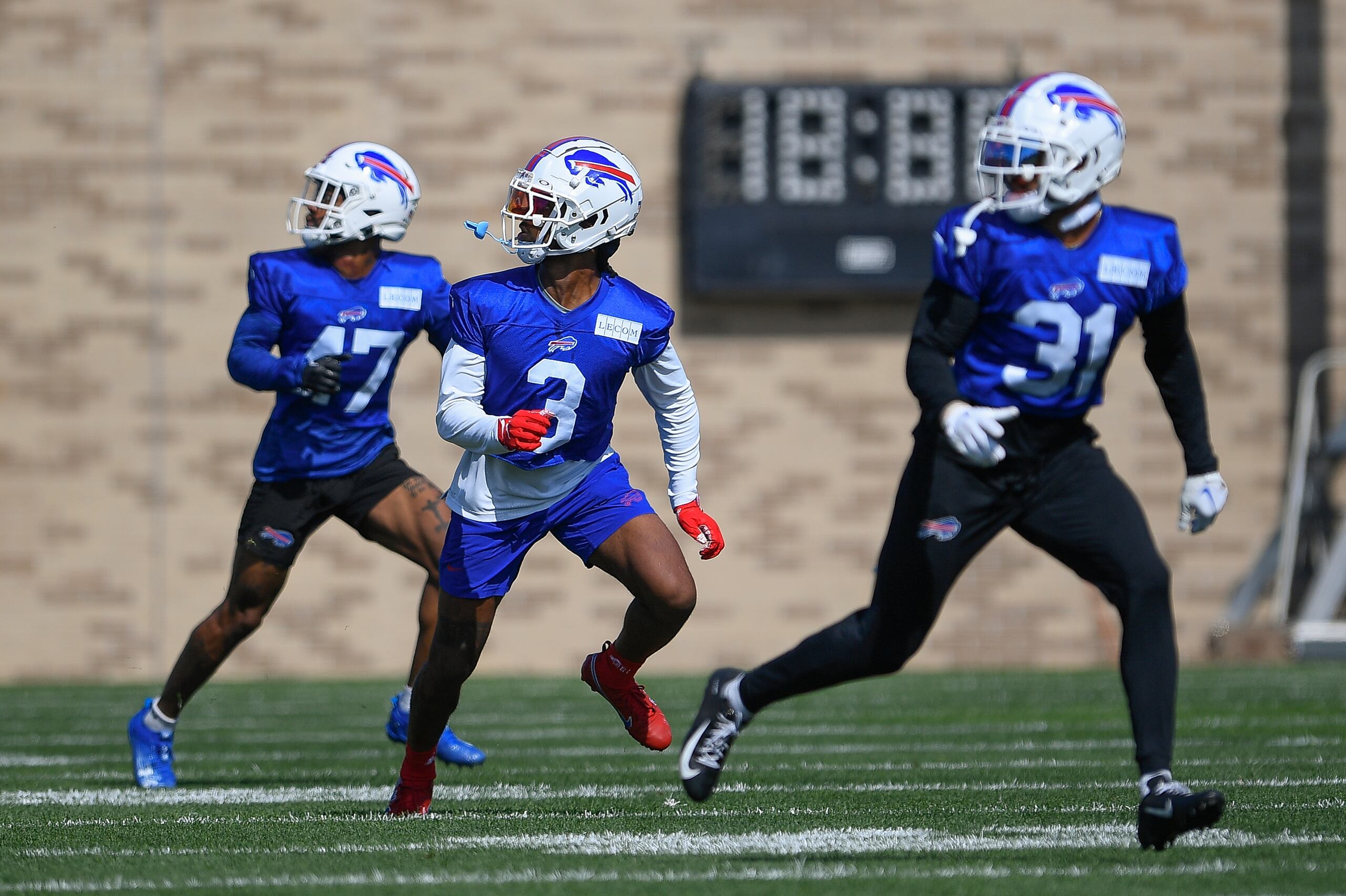 El safety de los Bills de Búfalo, Damar Hamlin, realiza un ejercicio con el cornerback Christian Benford y el safety Dean Marlowe en el campamento de entrenamiento en Pittsford, Nueva York el domingo 30 de julio del 2023.