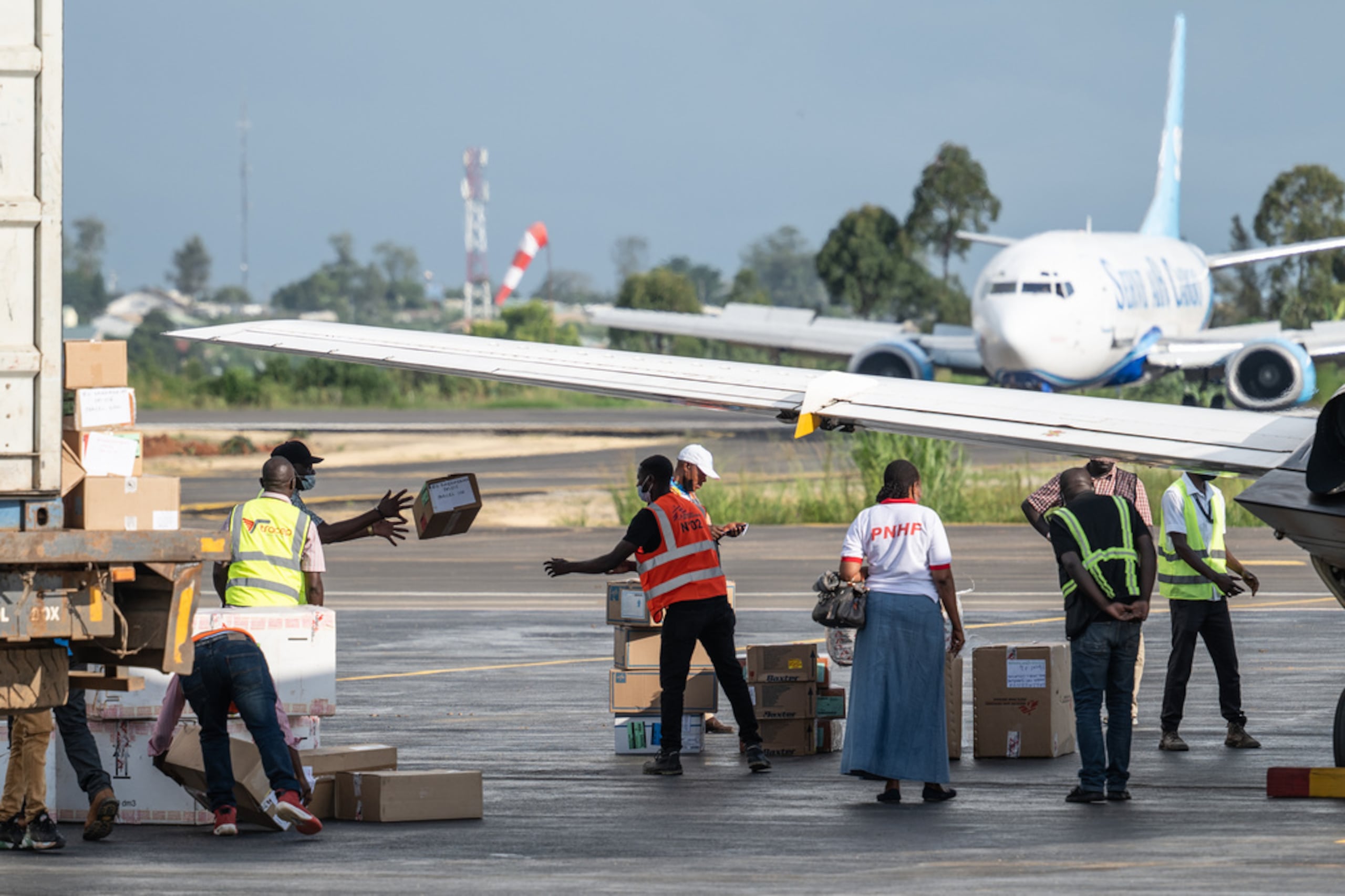 Personas descargan suministros en el Aeropuerto Nacional de Bunia como parte de la respuesta al brote del virus del ébola en Bunia, Congo, el martes, 19 de mayo de 2026.