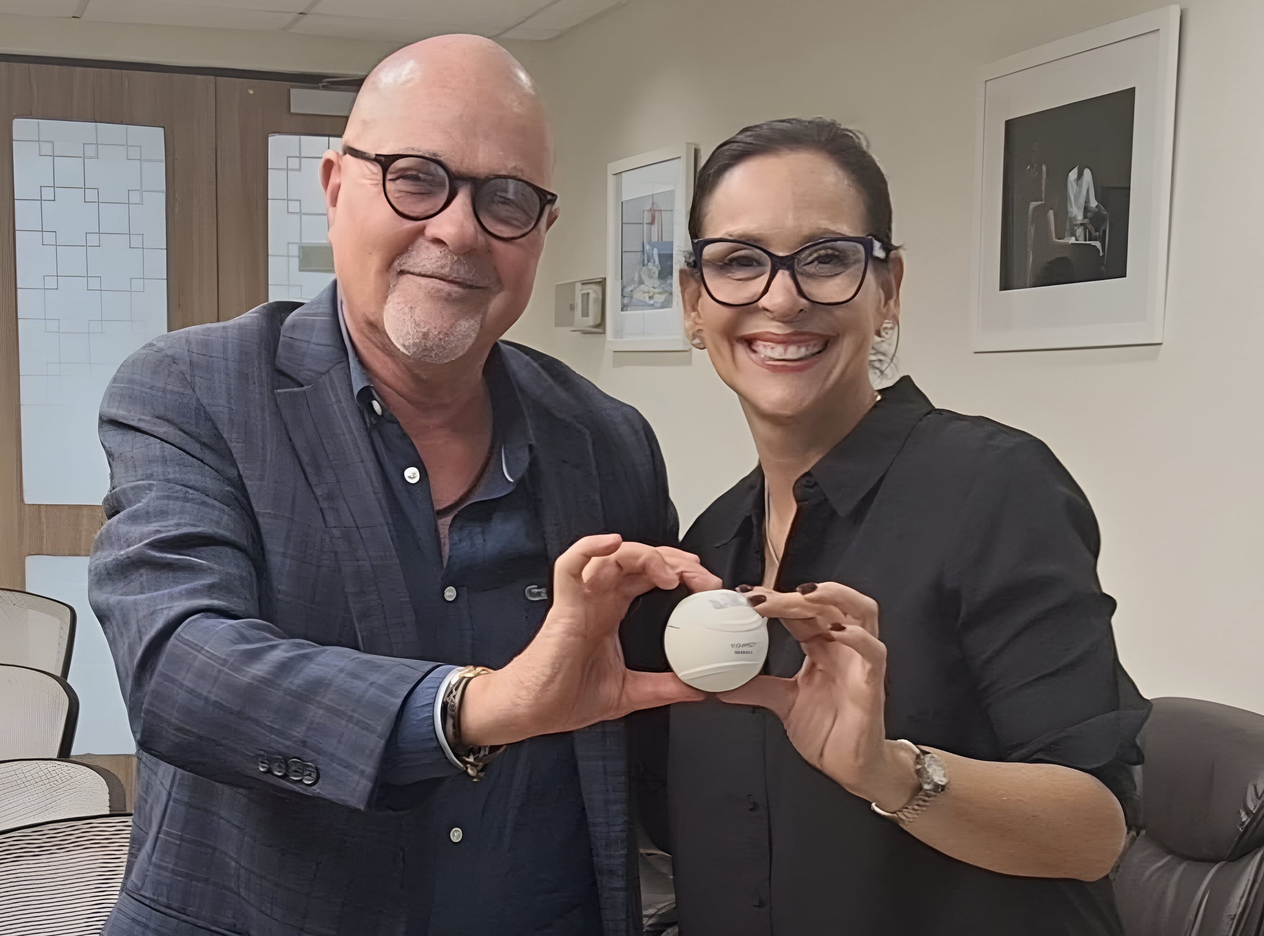El presidente de la Federación de Béisbol, Dr. José Quiles, y la secretaria del Departamento de Educación, Yanira Raíces, posan con una pelota oficial del juego Baseball5, una modalidad de la pelota de goma que se jugaba en las calles del país hace unas décadas.