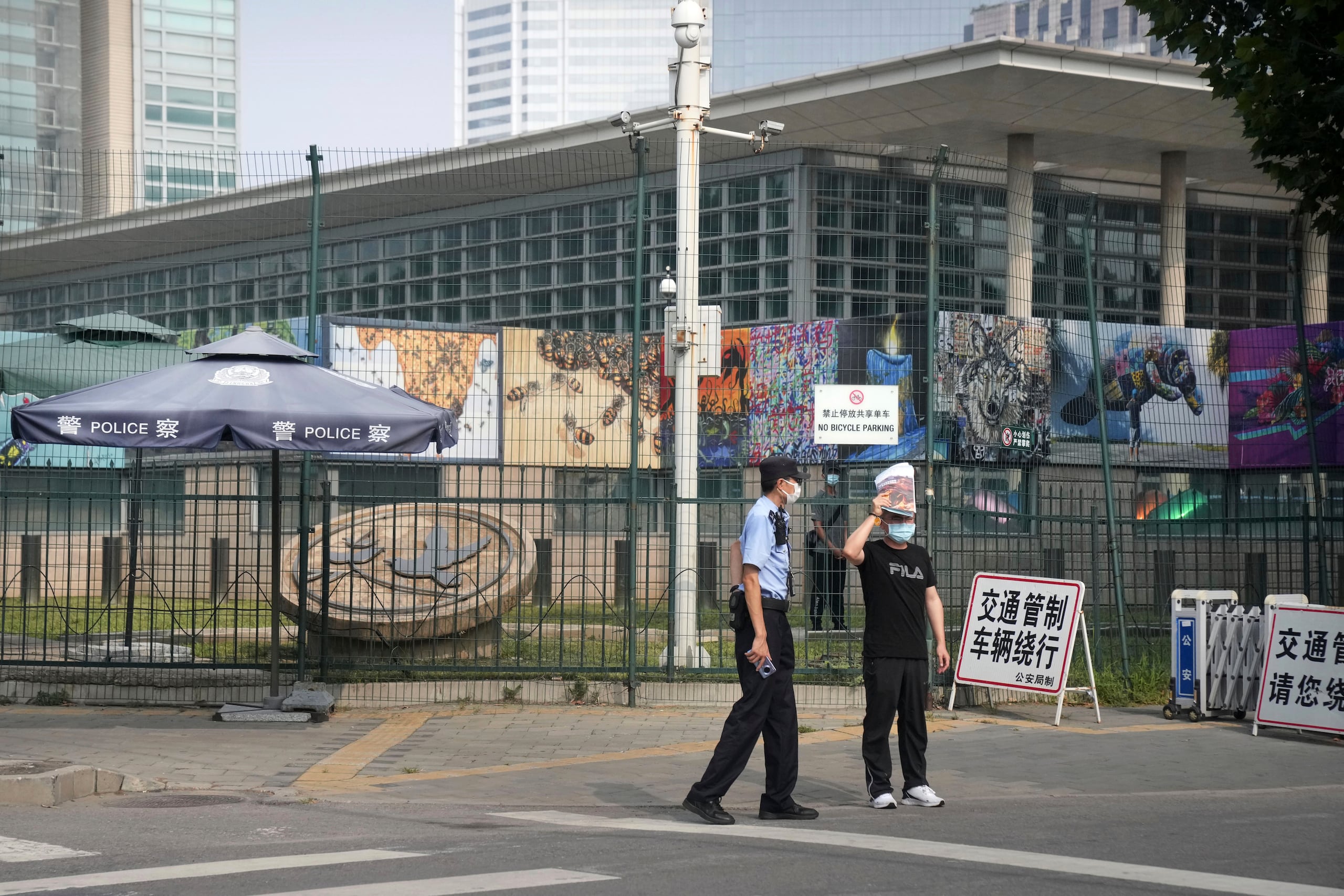 ARCHIVO - Agentes de seguridad uniformados y paisano montan guardia ante la Embajada de Estados Unidos en Beijjing, el 3 de agosto de 2022. (AP Foto/Mark Schiefelbein, Archivo)