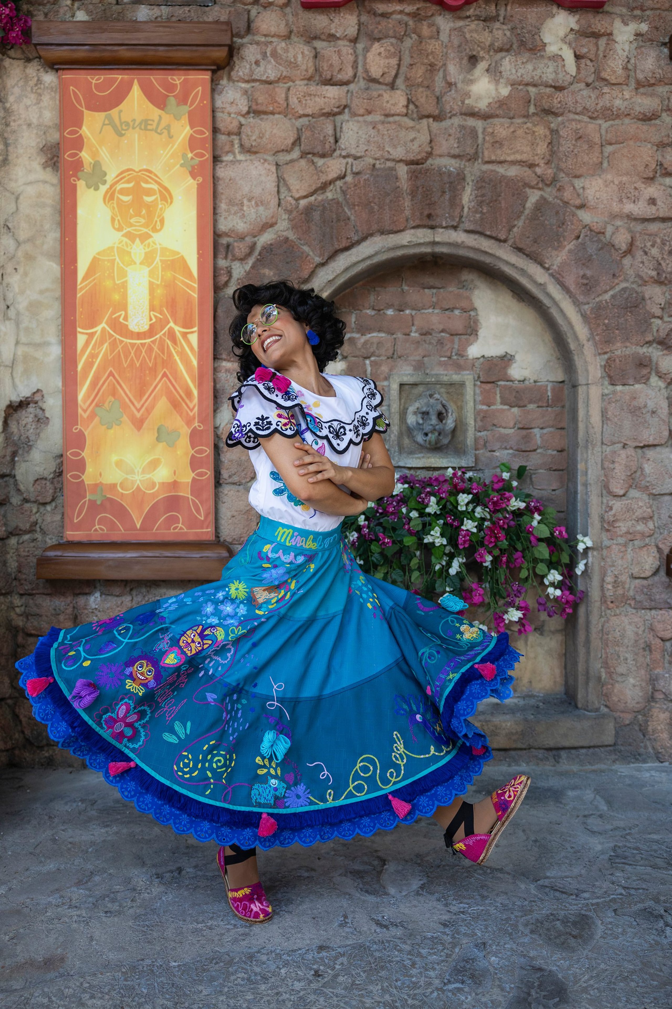 El personaje de "Mirabel", de la película "Encanto", es uno de los que se une este mes para recibir a los visitantes  en el colorido patio de la Casa Madrigal.