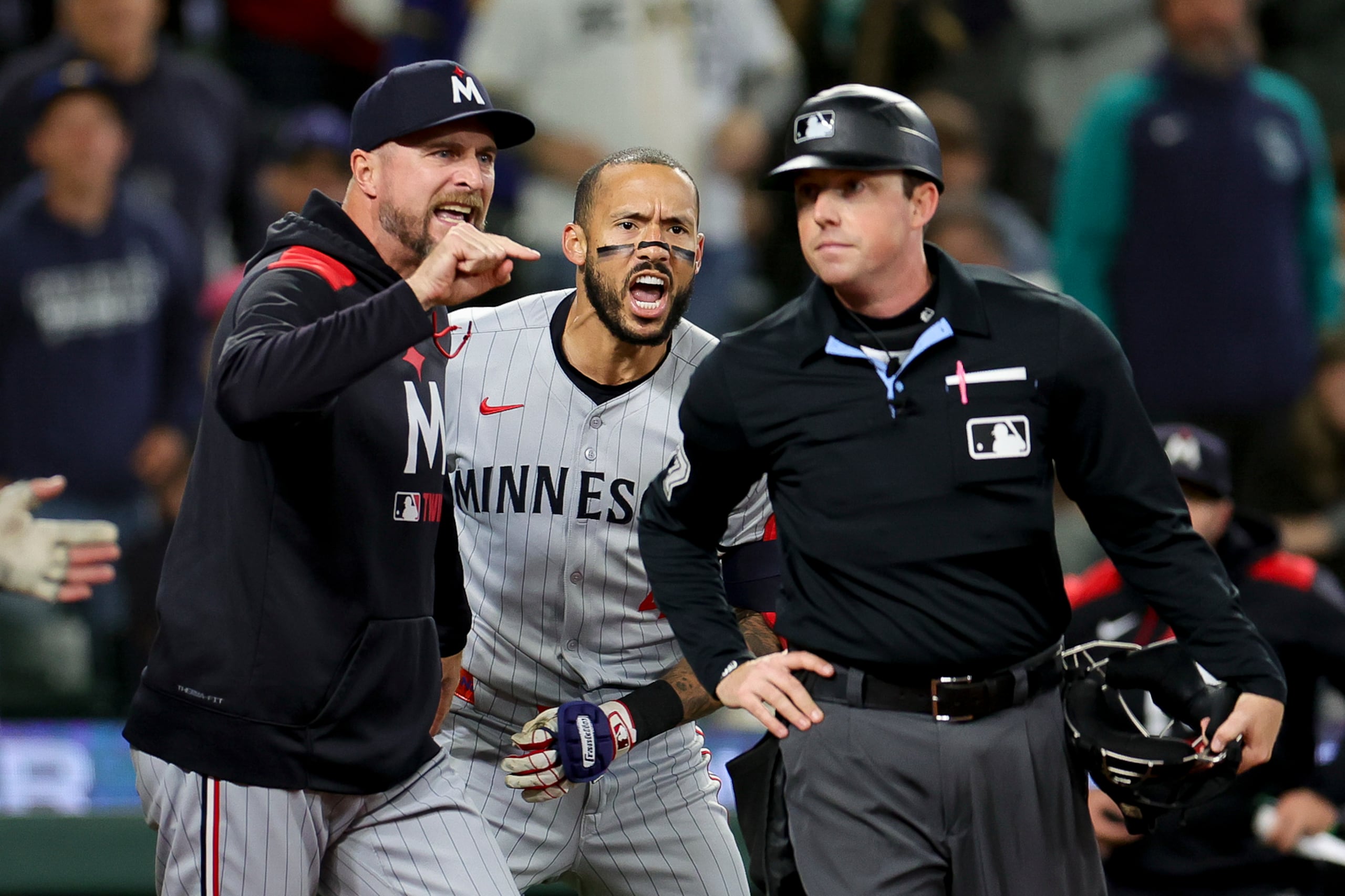 El dirigente Rocco Baldelli y el boricua Carlos Correa le argumentan airadamente al árbitro Austin Jones, tras ambos ser expulsados en el séptimo inning en el partido ante Seattle.