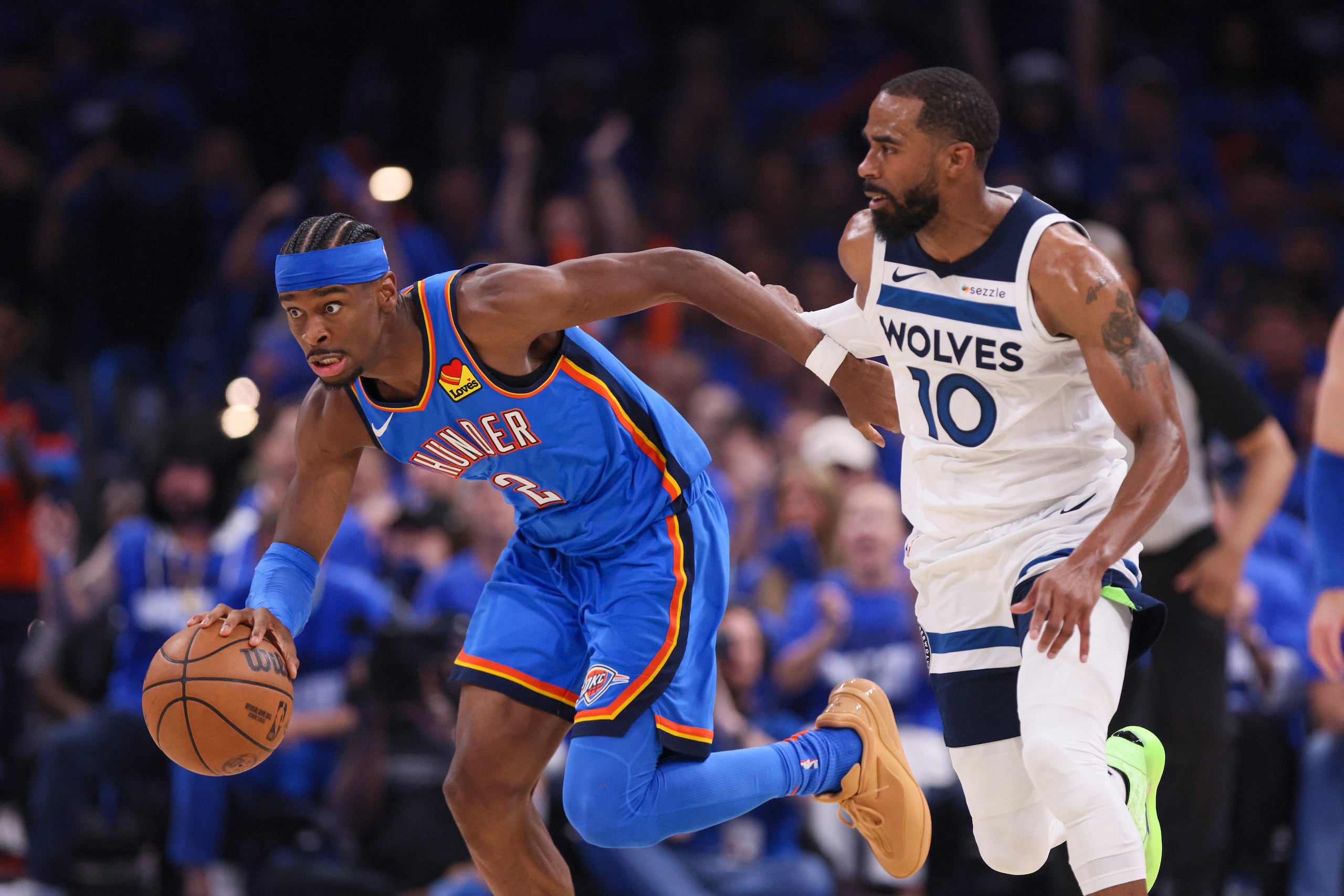 Shai Gilgeous-Alexander, del Thunder de Oklahoma City, maneja el balón ante la presión de Mike Conley, de los Timberwolves de Minnesota.
