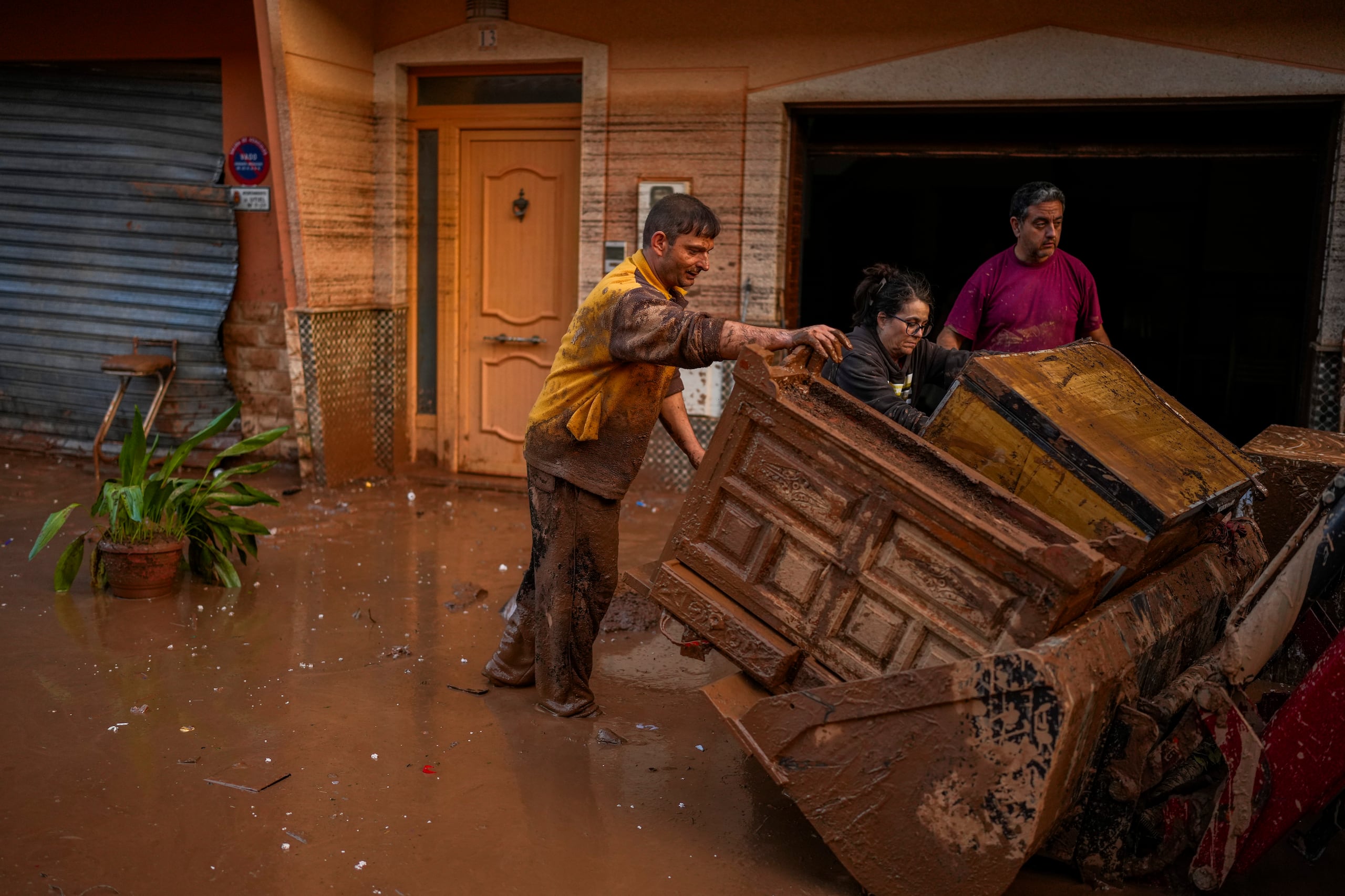 Personas limpian sus viviendas afectadas por las inundaciones en Utiel, España.