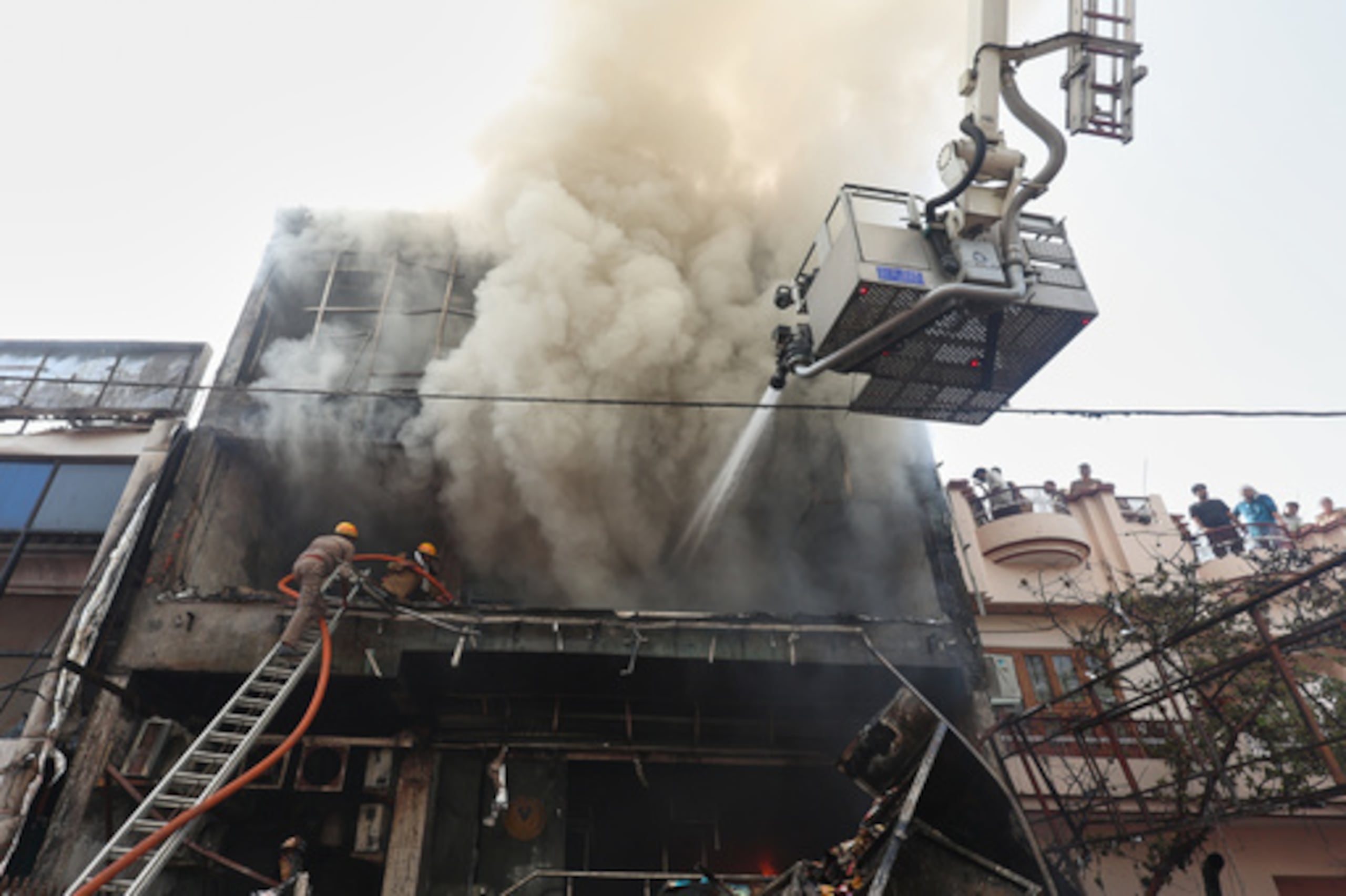Los bomberos trabajan para extinguir un incendio en un edificio comercial de Lucknow, India, el lunes 22 de junio de 2026. (Foto AP/Sumit Kumar)