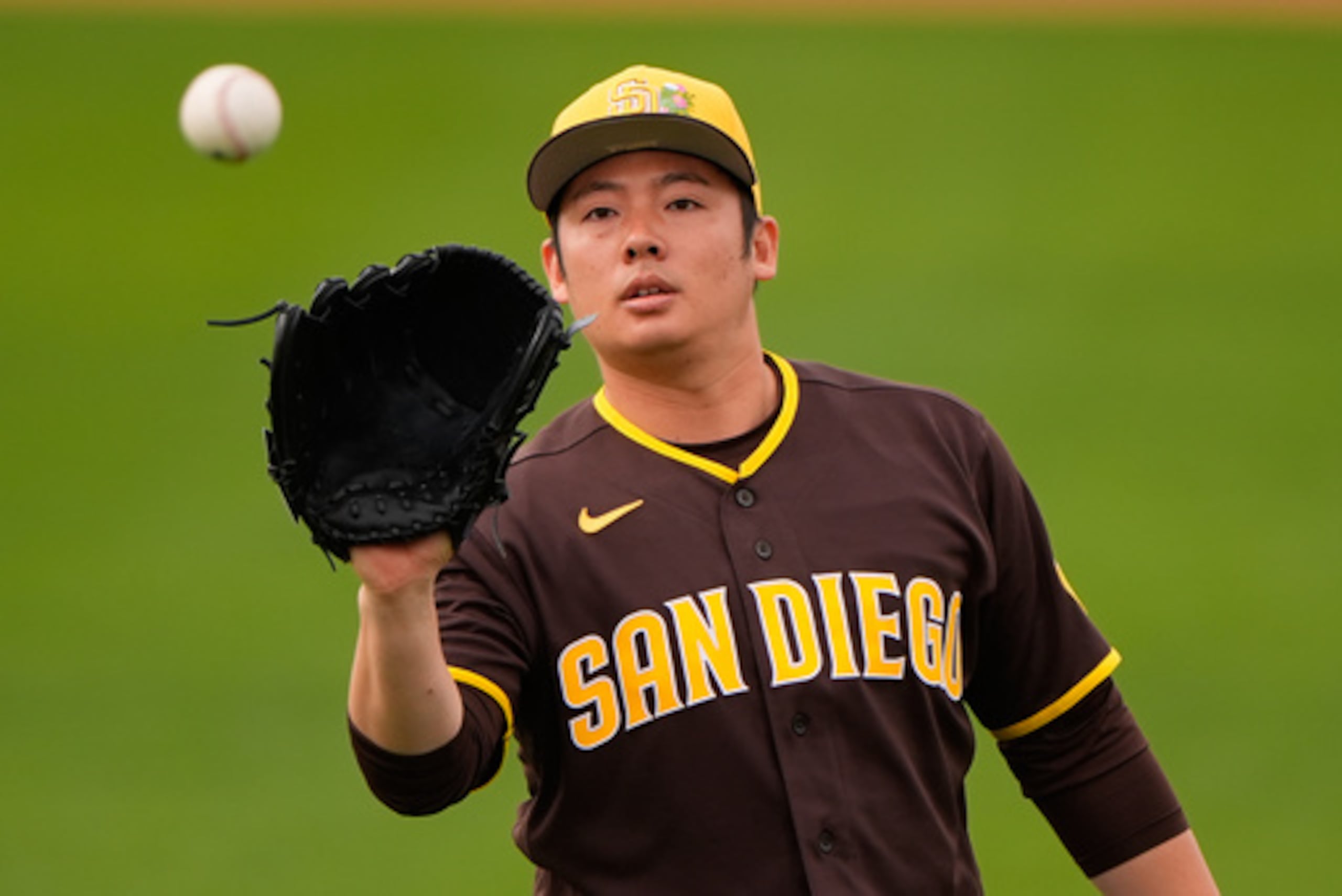 El japonés Yuki Matsui de los Padres de San Diego atrapa una pelota durante una práctica de béisbol de pretemporada el lunes 16 de febrero de 2026, en Peoria, Arizona. (AP Photo/Charlie Riedel)