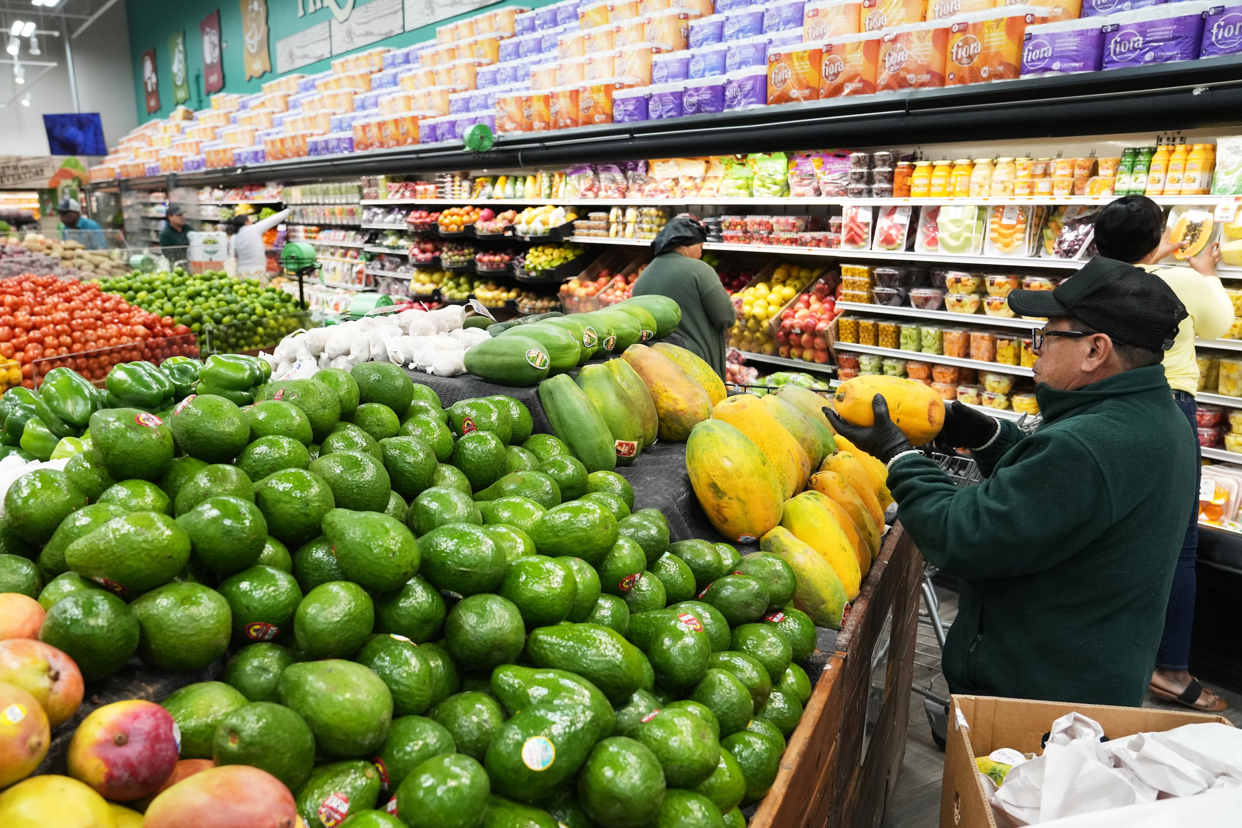 Un empleado coloca papayas en el supermercado Price Choice, que participa en el Programa de Asistencia Nutricional Suplementaria (SNAP) del Departamento de Agricultura de Estados Unidos (USDA), el viernes 14 de noviembre de 2025, en Miami. (AP Foto/Lynne Sladky)