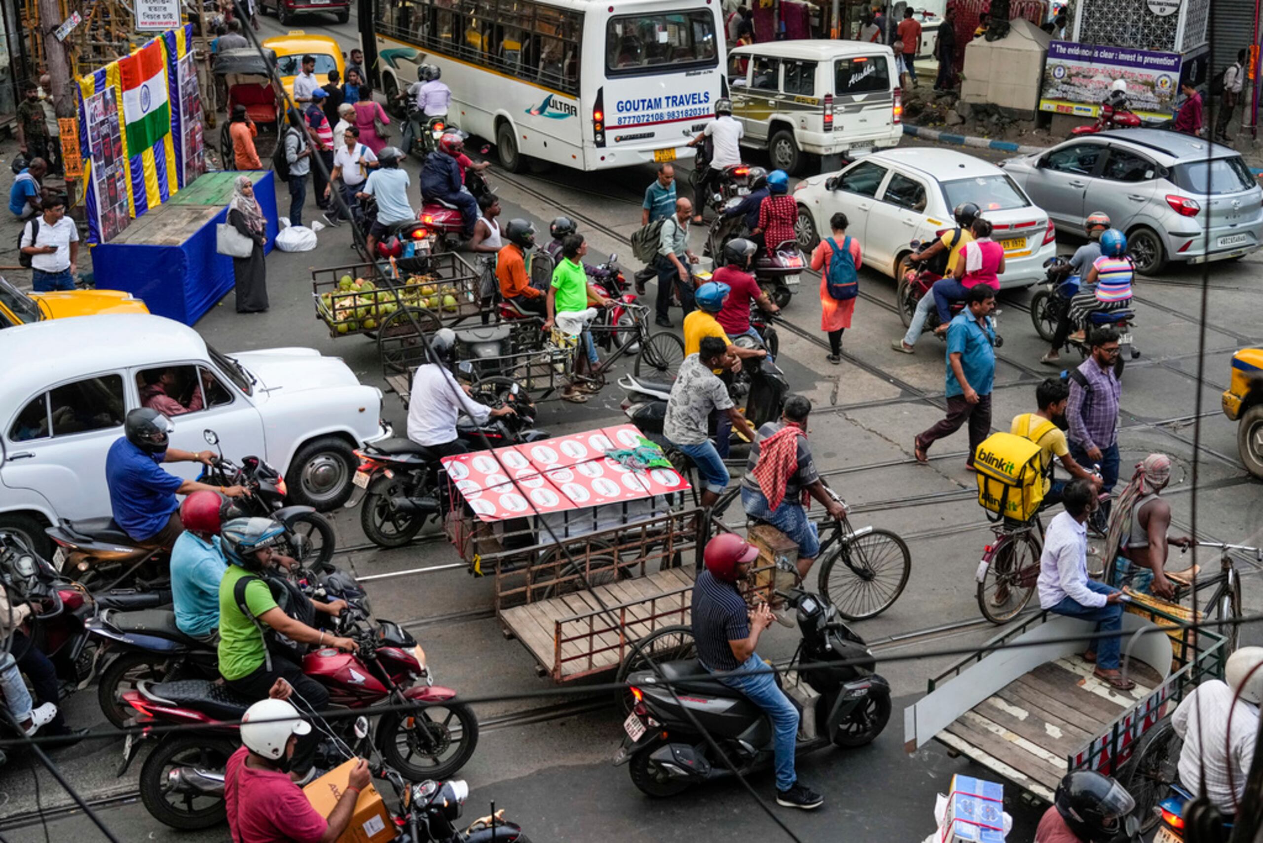 Peatones y varios tipos de vehículos en un cruce de calles el 1 de octubre de 2024, en Calcuta, India.