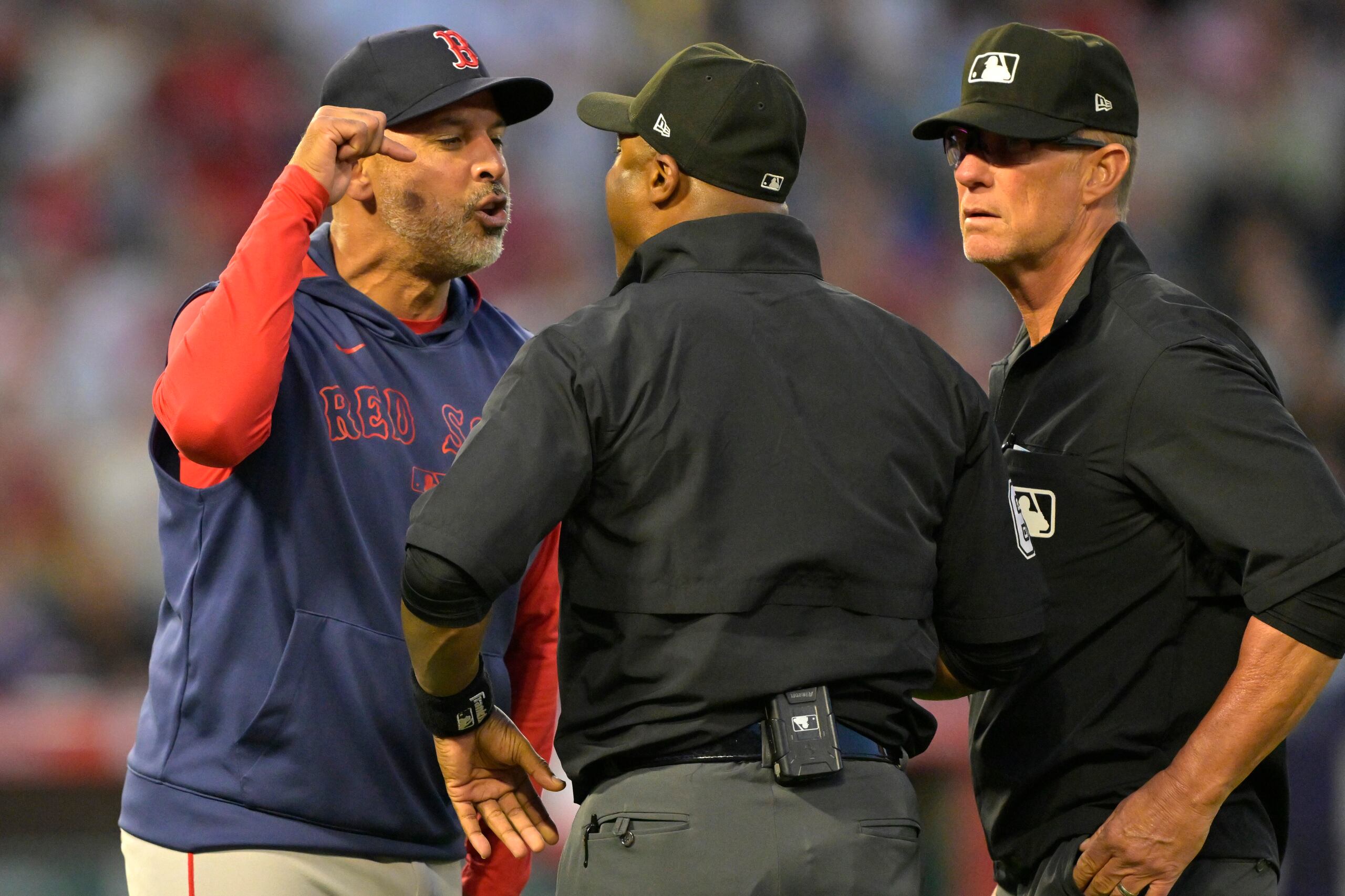 El mánager de los Red Sox de Boston Alex Cora discute con el umpire Alan Porter y Jim Wolf tras ser expulsado en la quinta entrada ante los Angels.