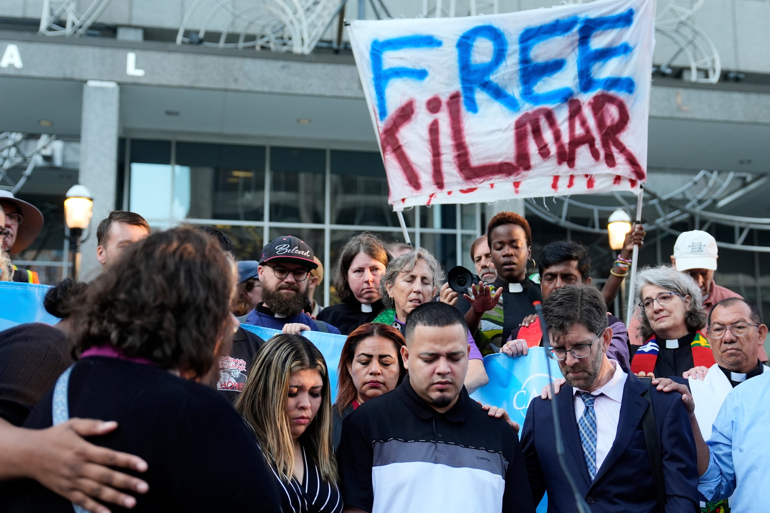 De frente desde la derecha, el abogado Simon Sandoval-Moshenberg, Kilmar Abrego García y su esposa Jennifer Vásquez Sura asisten a una manifestación frente a la oficina del Servicio de Inmigración y Control de Aduanas (ICE) en Baltimore, el lunes 25 de agosto de 2025.
