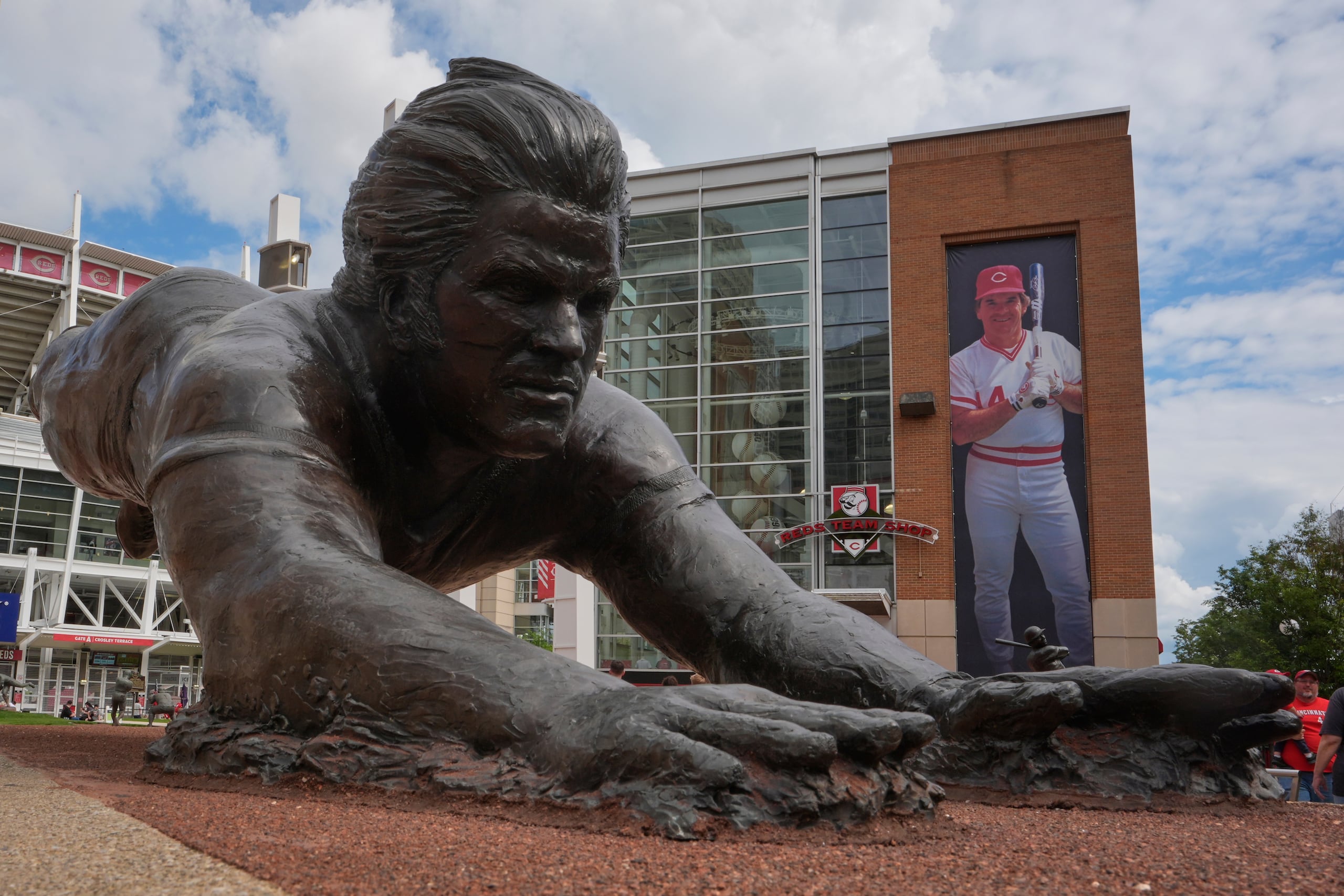 Una estatua de bronce y pancarta de Pete Rose, ex pelotero de los Rojos de Cincinnati, afuera del estadio Great American Ball Park, el martes 13 de mayo de 2025, Cincinnati. (AP Foto/Carolyn Kaster)