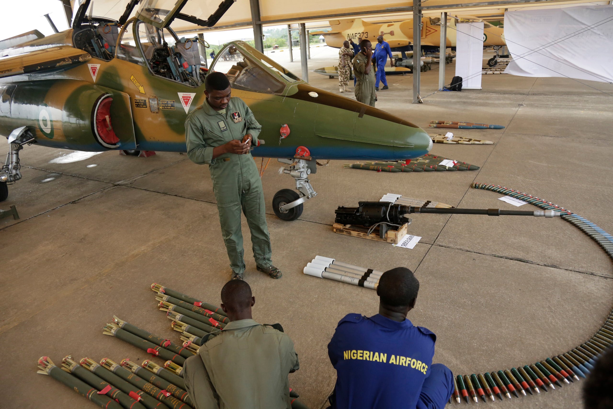 ARCHIVO - En esta foto del 22 de abril de 2017, oficiales de la Fuerza Aérea Nigeriana muestran municiones junto a un avión de combate durante un evento en Makurdi, Nigeria. (Foto AP/ Sunday Alamba, archivo)