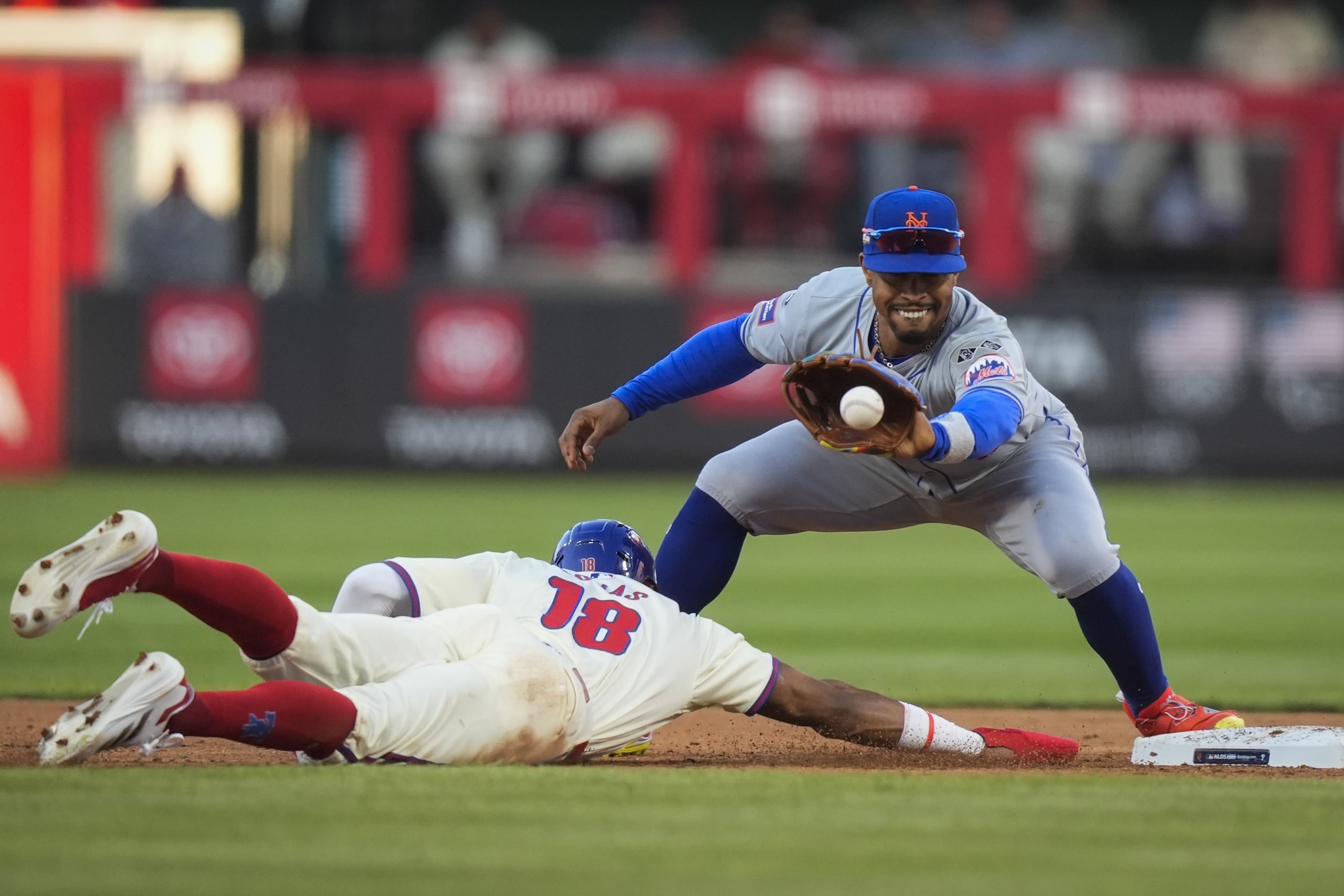 Francisco Lindor intenta sacar fuera en segunda base a Johan Rojas durante el primer partido de serie divisional entre Mets y Phillies.
