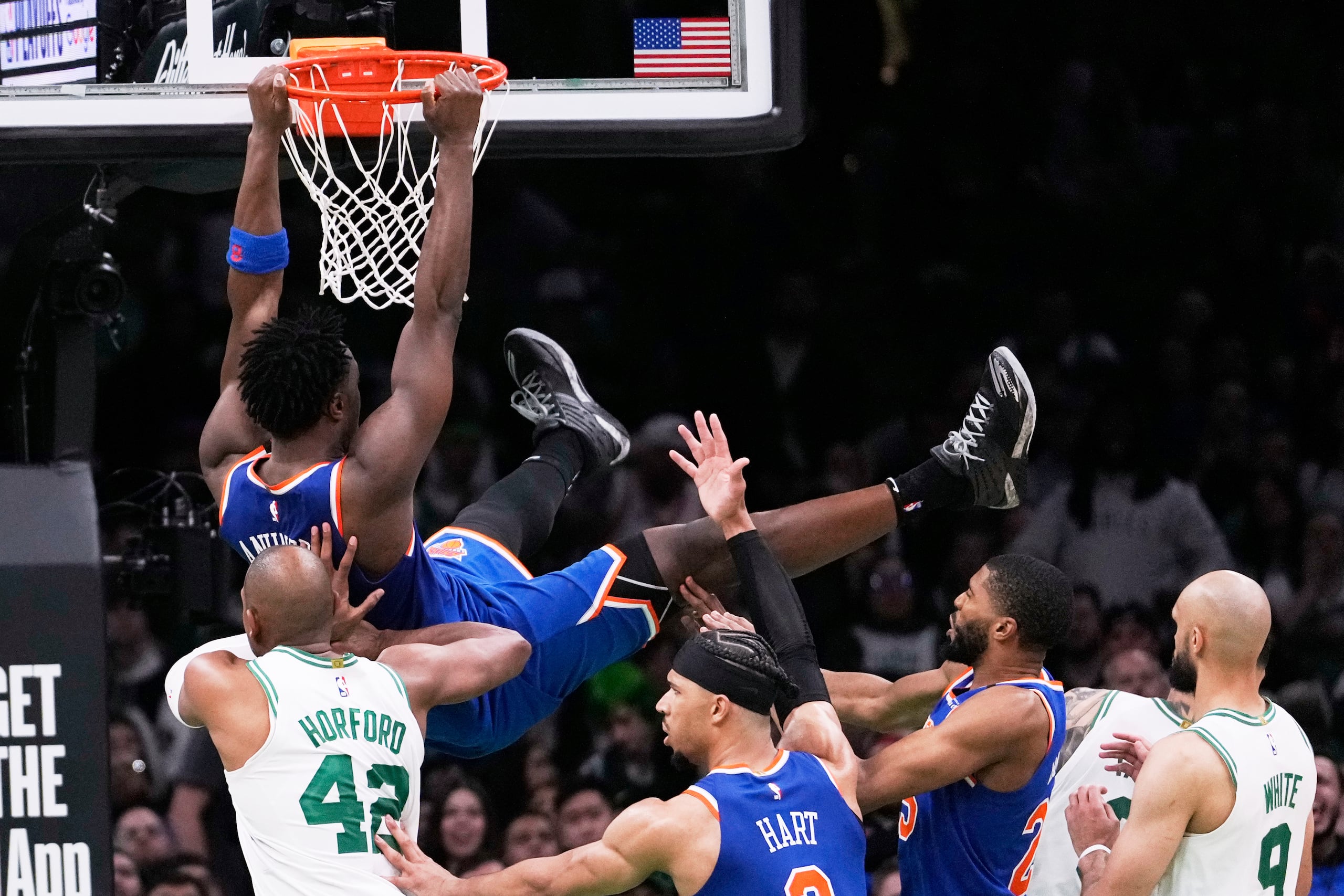 El alero de los Knicks de Nueva York OG Anunoby se sostiene del aro tras clavar el balón en el primer encuentro de la serie de semifinales de la Conferencia Este ante los Celtics de Boston el lunes 5 de mayo del 2025. (AP Foto/Charles Krupa)