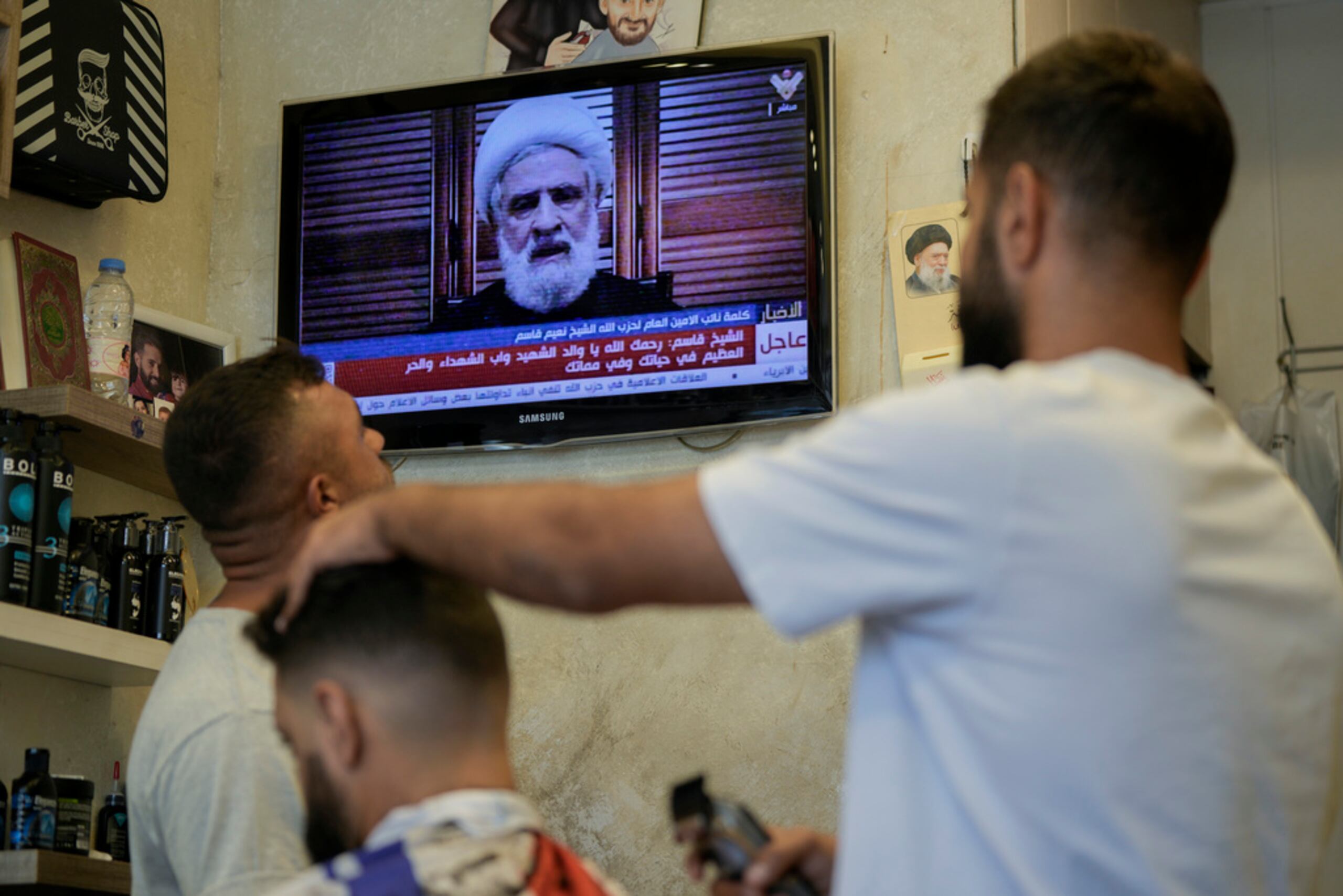 La gente escucha un discurso del sublíder de Hezbollah, Naim Qassem, transmitido por el canal de televisión Al-Manar de Hezbollah, en una barbería en Beirut, Líbano, el 30 de septiembre de 2024.