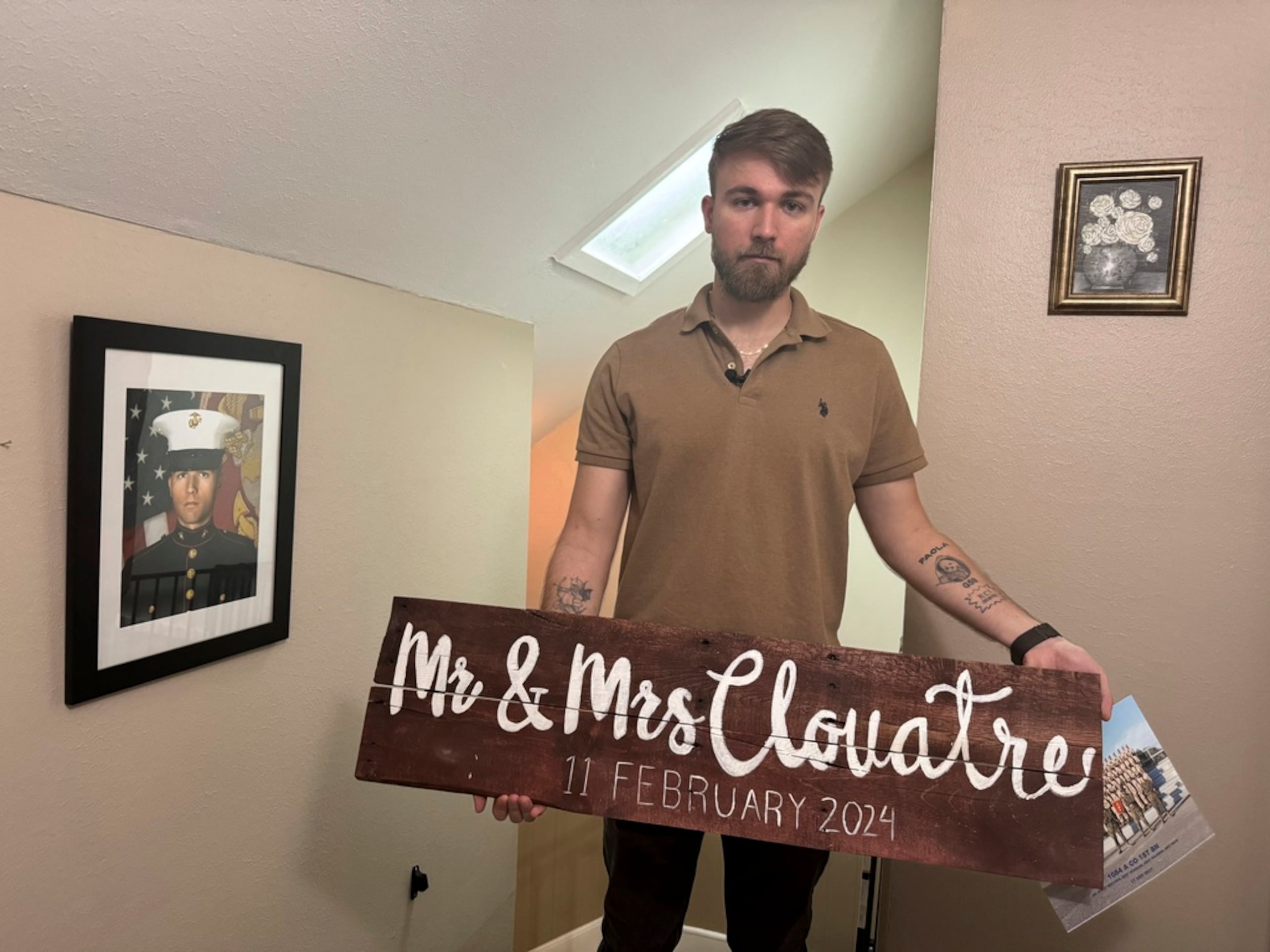 Adrian Clouatre, sostiene un cartel de su boda en su hogar en Baton Rouge, Luisiana.