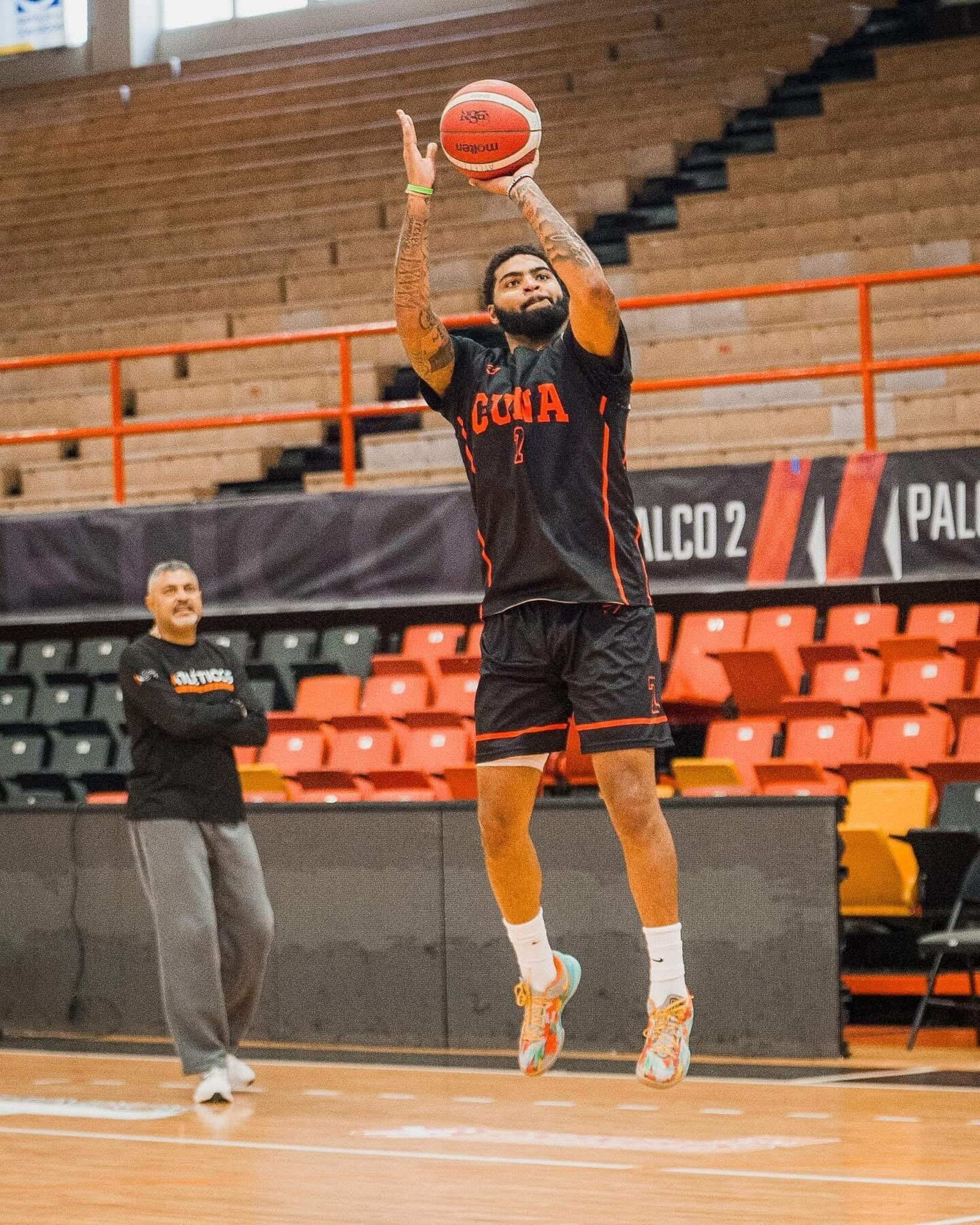 E.J. Crawford es uno de los nuevos jugadores que los Atléticos de San Germán adquirieron para la temporada 2025 del BSN. En el fondo, el dirigente Eddie Casiano.