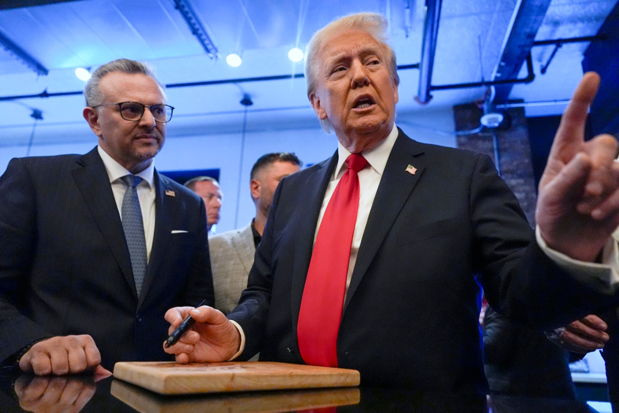 Donald Trump firma autógrafos a un costado de Massad Boulos, el 1 de noviembre de 2024, en Dearborn, Michigan.