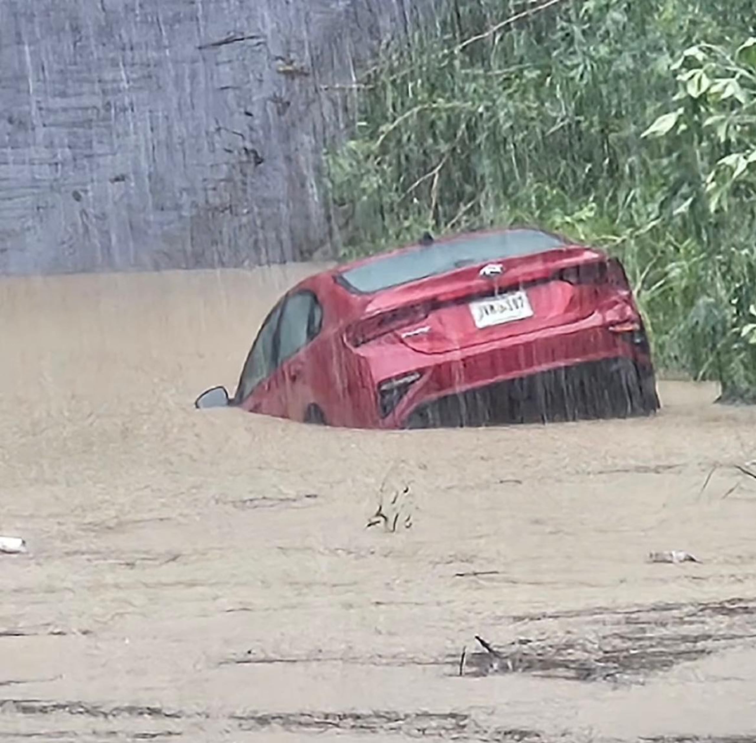 Imagen del automóvil que conducía un hombre de 69 años, tras ser arrastrado por la crecida de una quebrada en el Camino Navarro, en Caimito,