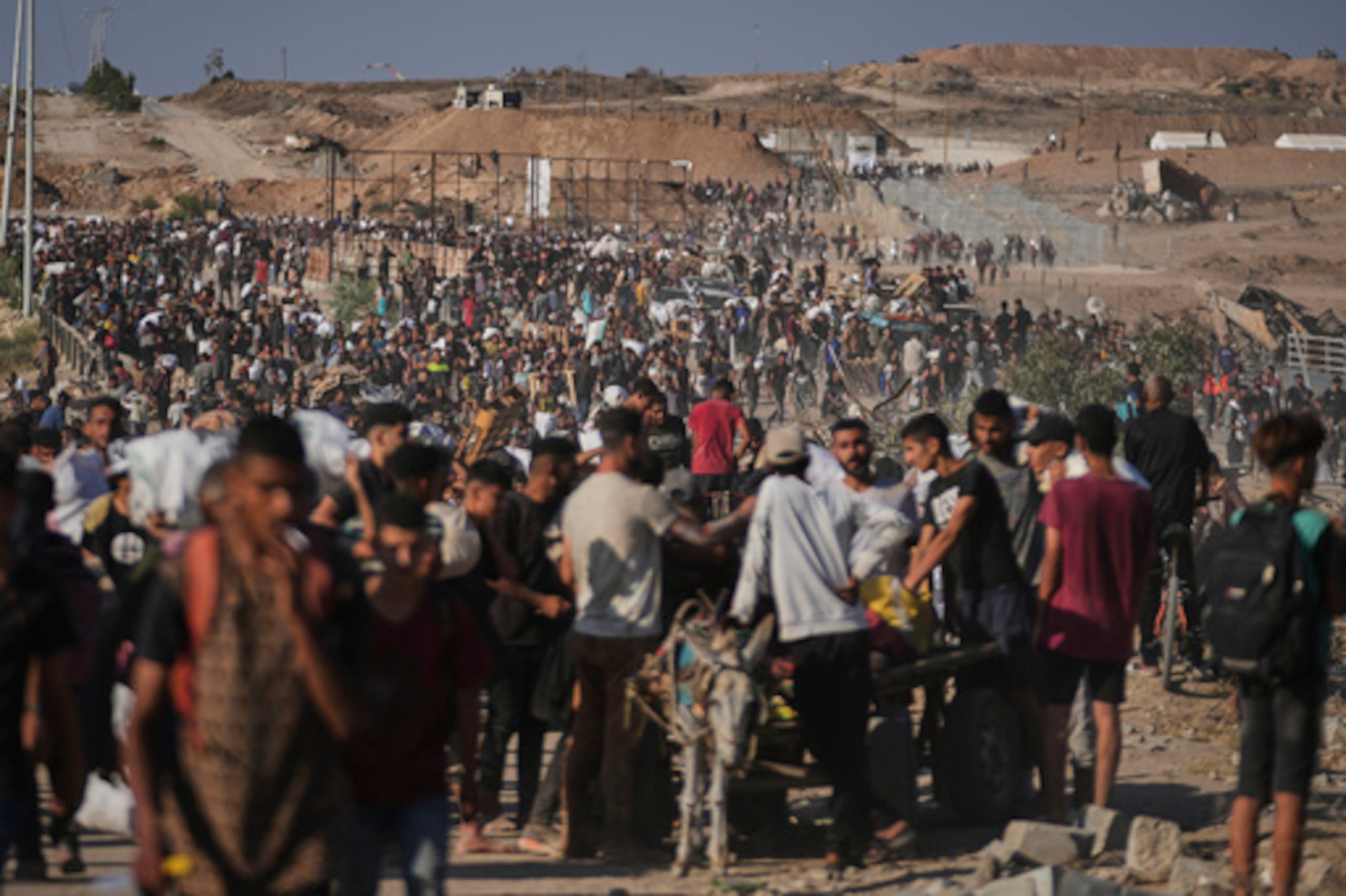 Palestinos reciben ayuda humanitaria en Gaza. Las muertos entre los palestinos aha aumentado a 56,500.