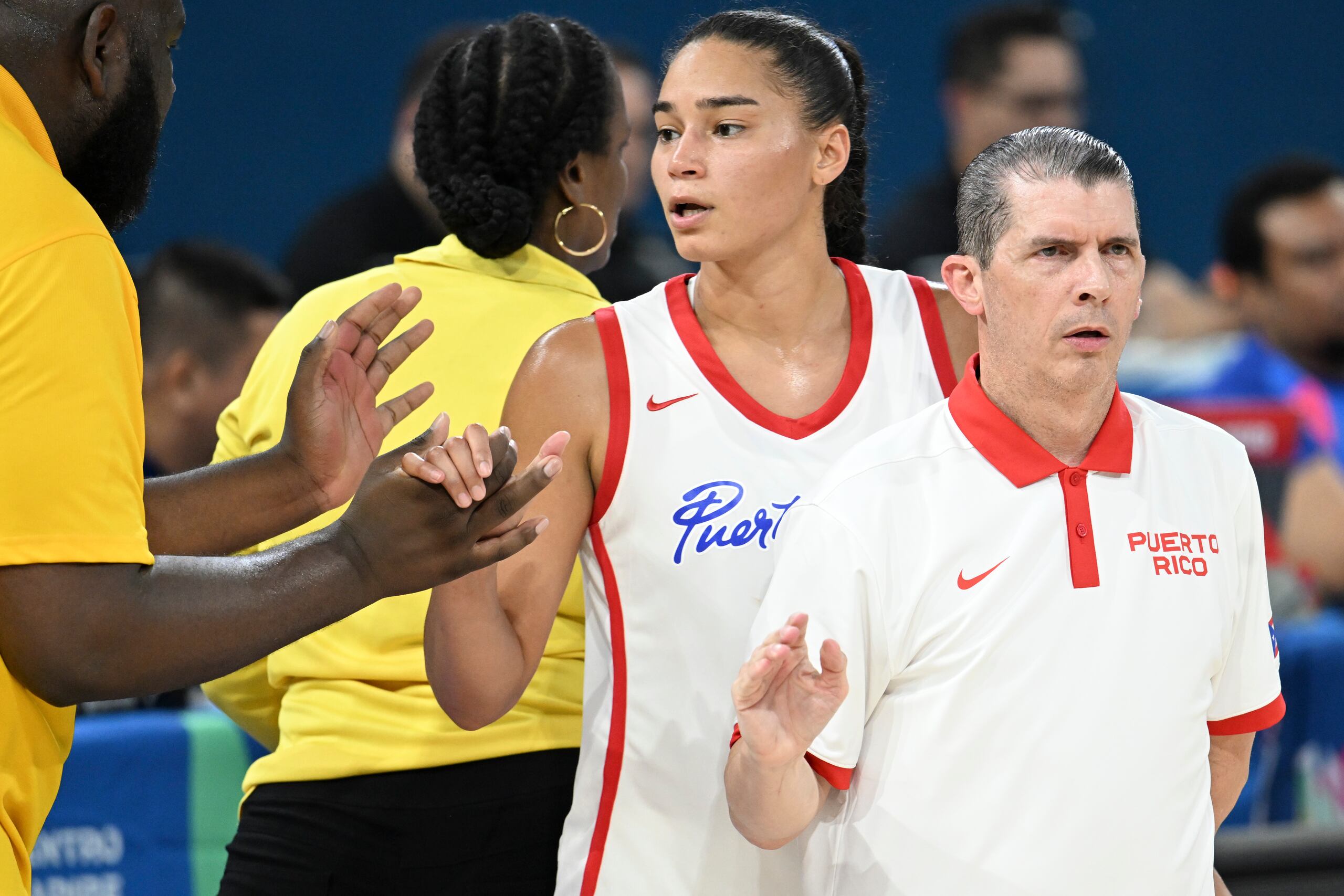 El dirigente de Puerto Rico, Jerry Batista, saluda a las ganadoras tras el partido.