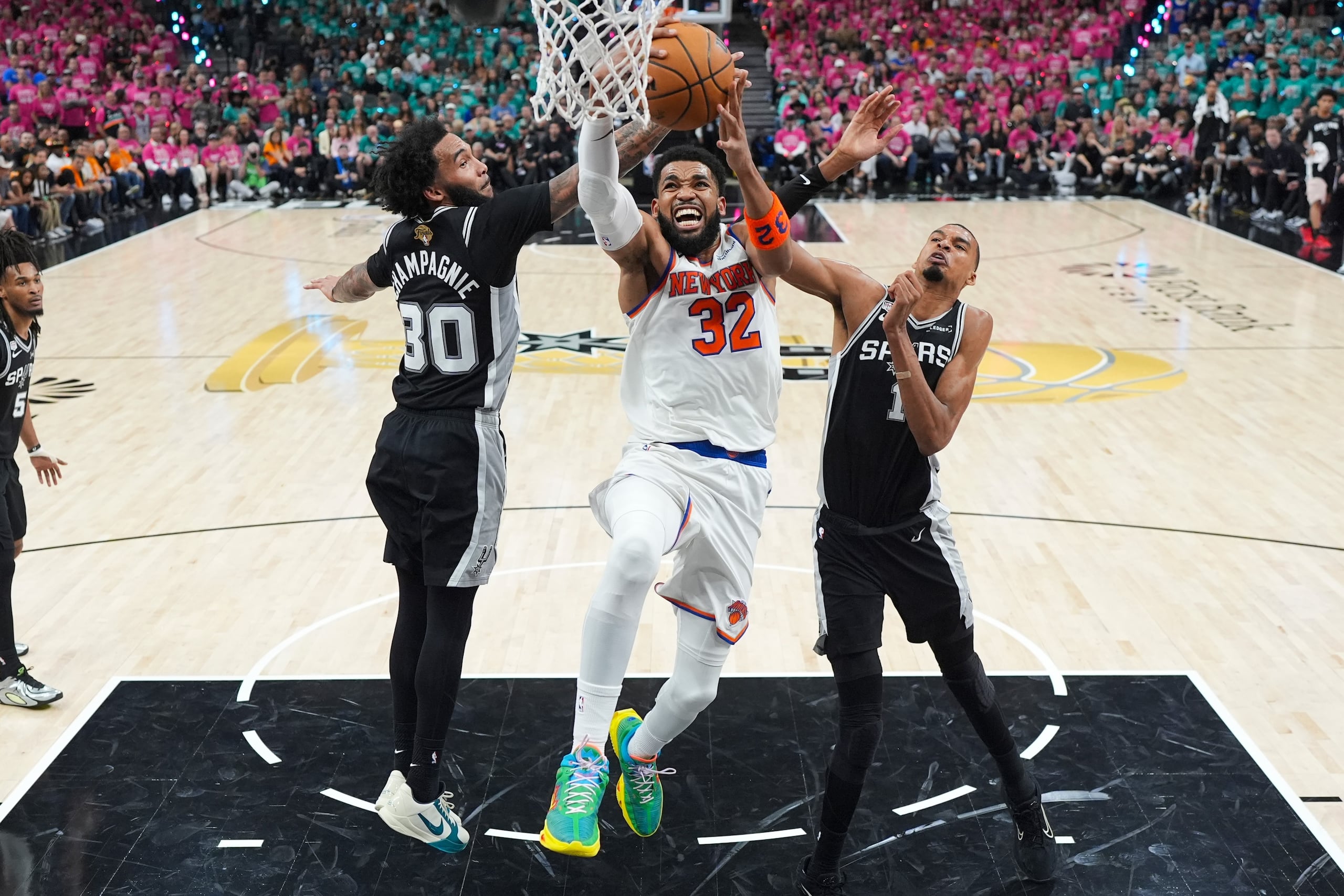 Karl-Anthony Towns, de los Knicks de Nueva York, lanza entre Victor Wembanyama y Julian Champagnie, de los Spurs de San Antonio.