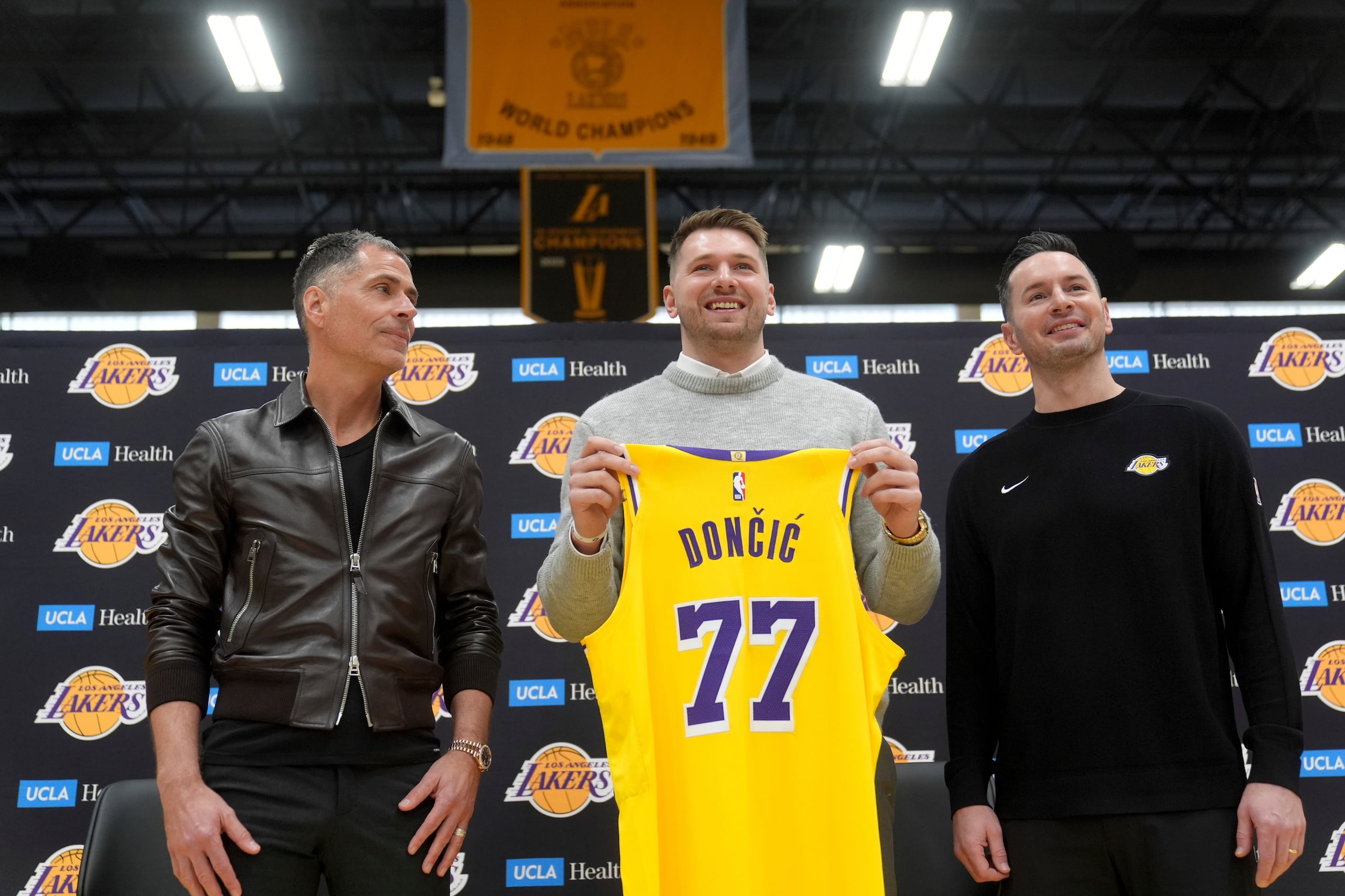 De izquierda a derecha, el gerente general de Los Angeles Lakers, Rob Pelinka, Luka Doncic y dirigente JJ Redick.