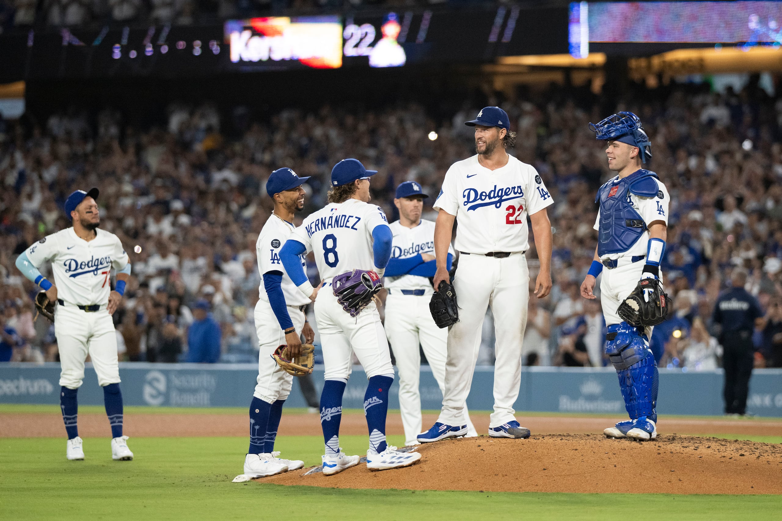 Clayton Kershaw conversa con compañeros instantes antes de ser relevado por última vez en un partido de temporada regular en el Dodgers Stadium.