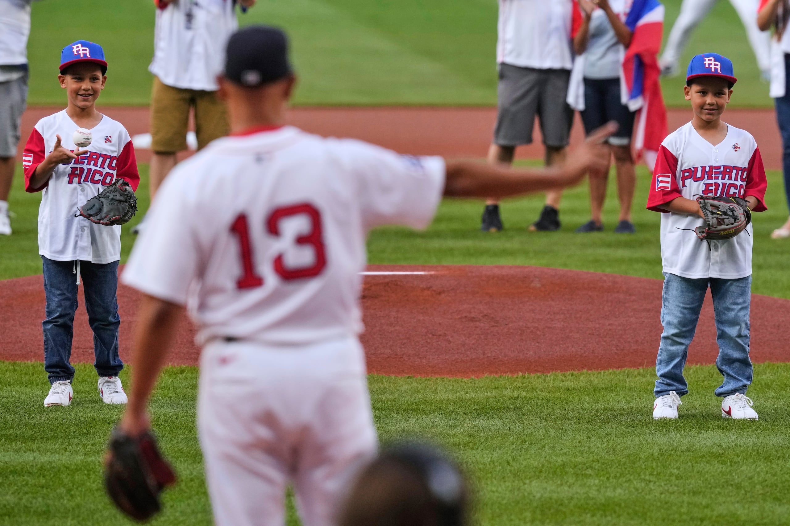 Xander e Isander Cora en el lanzamiento de honor junto a su padre, el dirigente de Boston, Alex Cora (13).