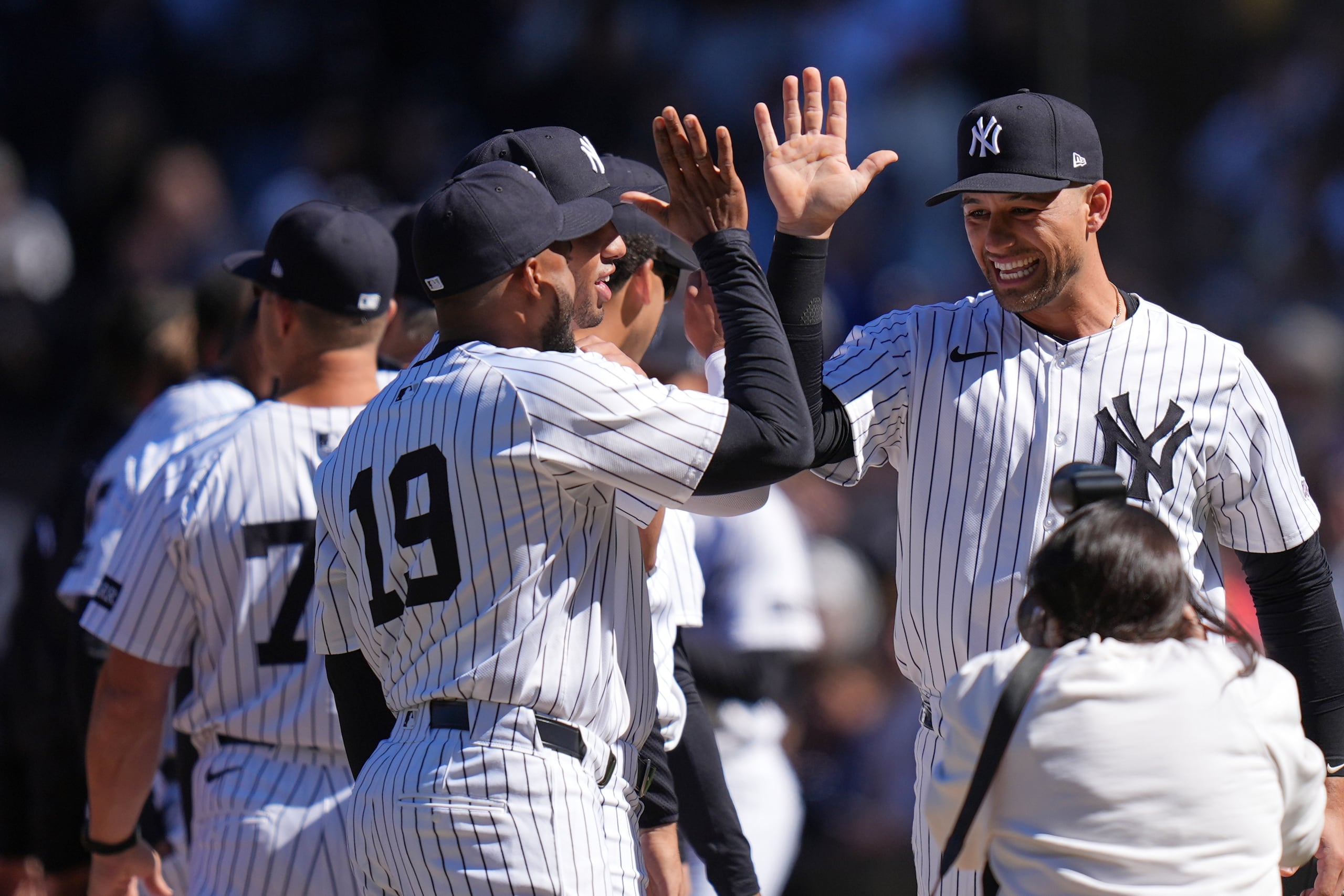 J.C. Escarra, a la derecha, saluda a sus compañeros de los Yankees de Nueva York previo al juego del Día Inaugural contra los Brewers de Milwaukee.