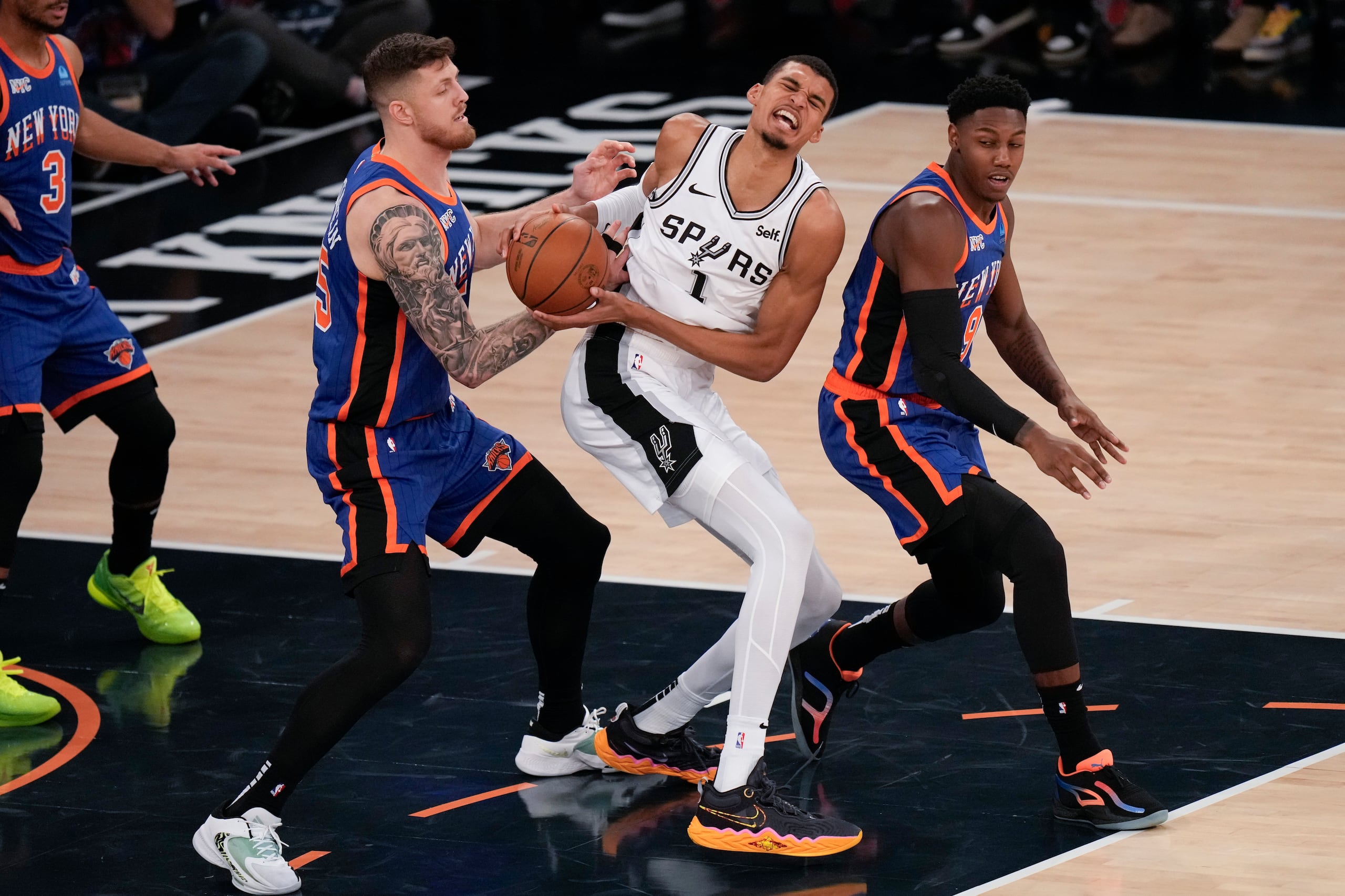 Isaiah Hartenstein, a la izquierda, y RJ Barrett, a la derecha, doblan al novato de los Spurs, Victor Wembanyama.