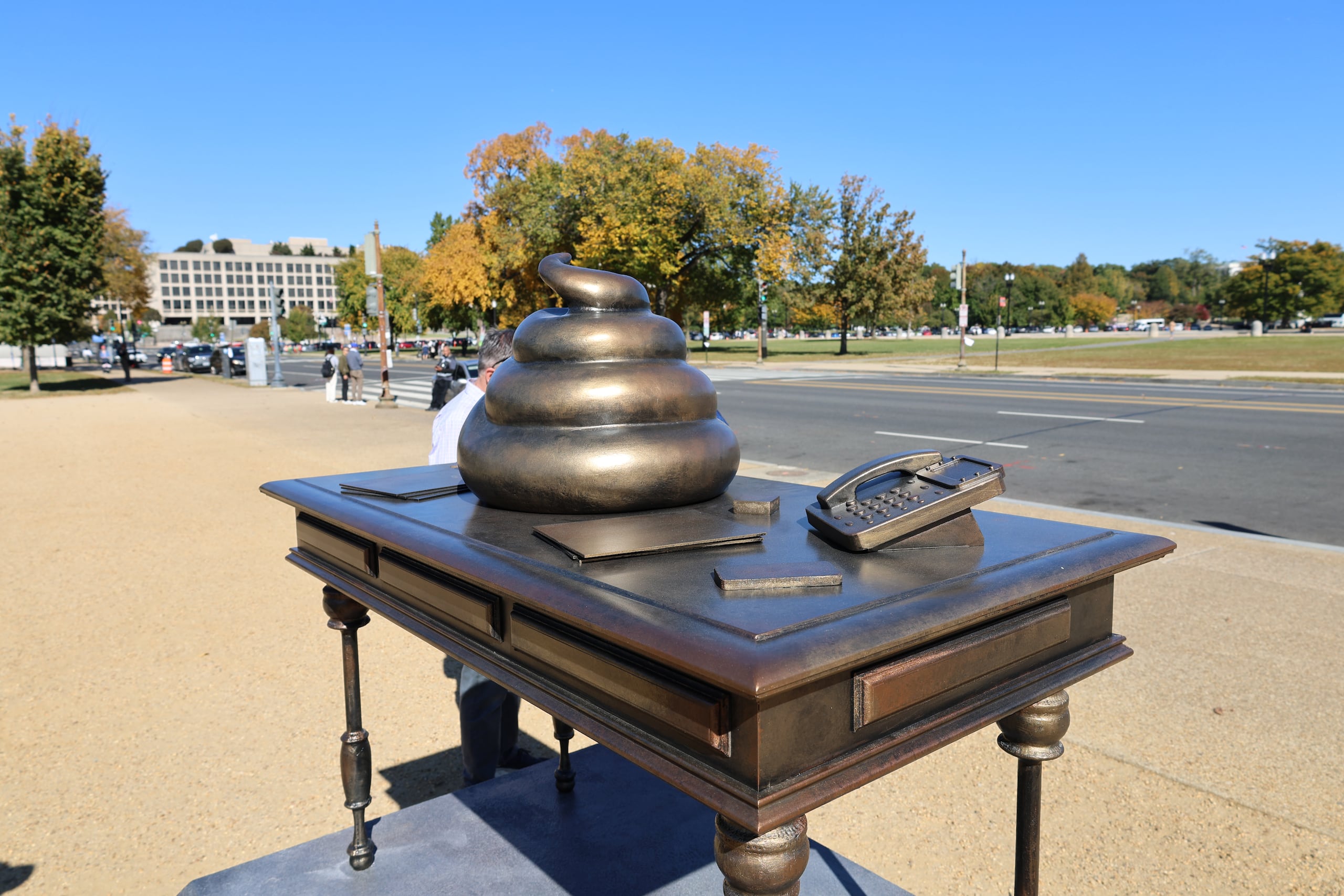 Una figura en bronce de un escritorio con un excremento encima, instalado en el National Mall cerca del Capitolio, recuerda el asalto al edificio del 6 de enero de 2021, cuando centenares de seguidores del expresidente Donald Trump intentaron frenar la ratificación de la victoria del actual mandatario, Joe Biden.