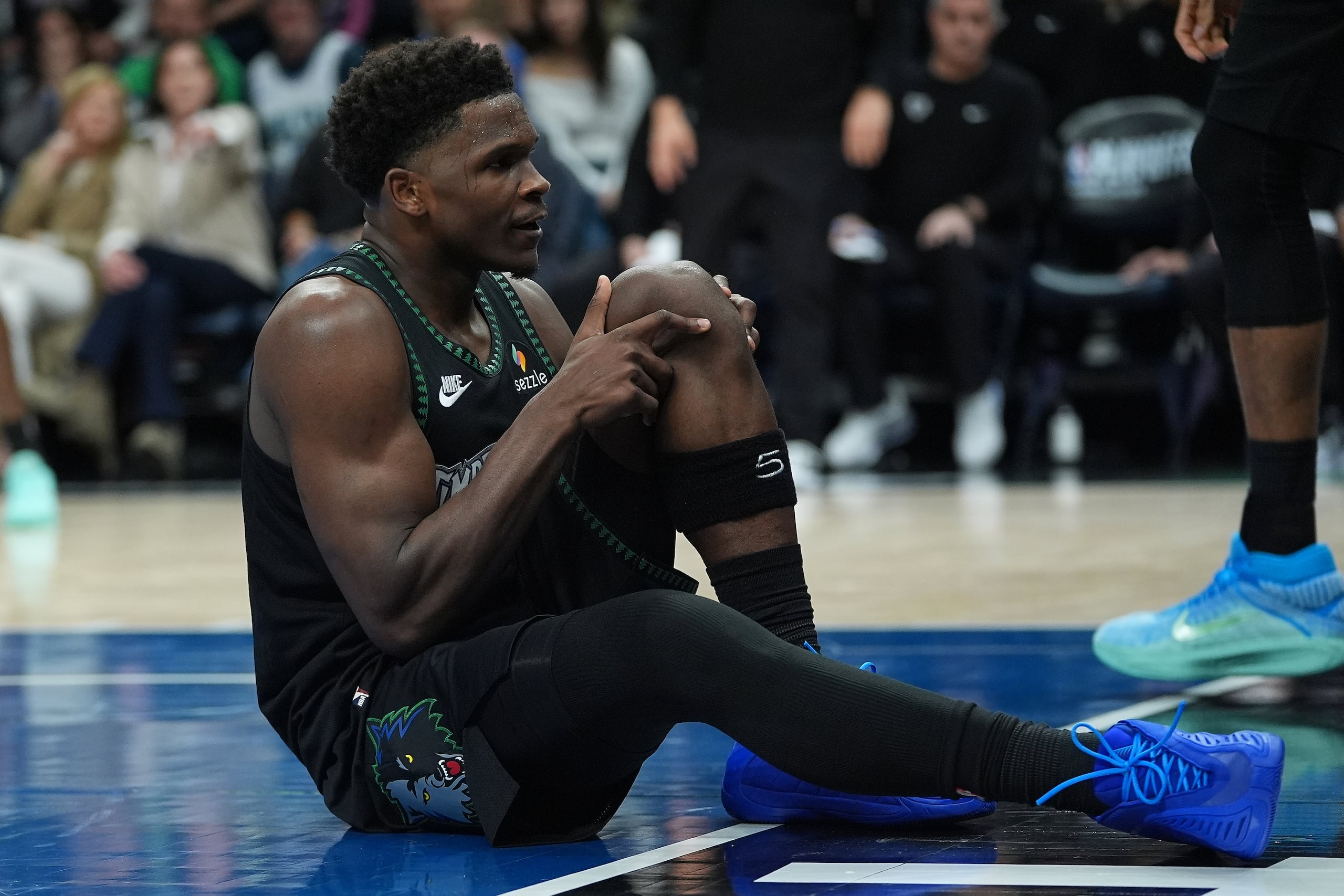 El base de los Timberwolves de Minnesota Anthony Edwards se toma la rodilla tras lesionarse en el juego 4 de la primera ronda de los playoffs ante los Nuggets de Denver el sábado 25 de abril del 2026. (AP Foto/Abbie Parr)