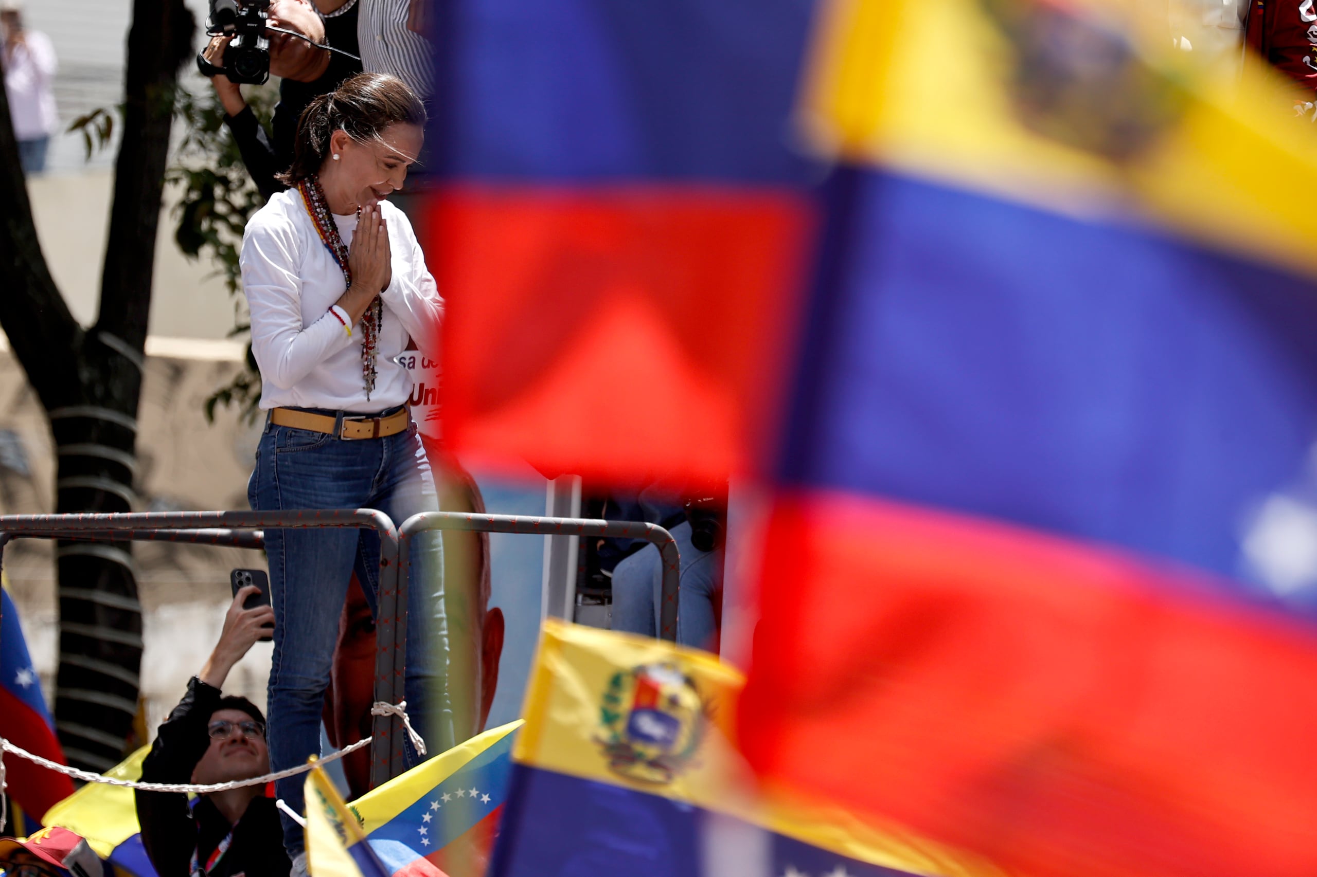 , Machado llegó montada en el techo de un camión a la concentración en el este de la capital, donde fue recibida con el canto del himno nacional.