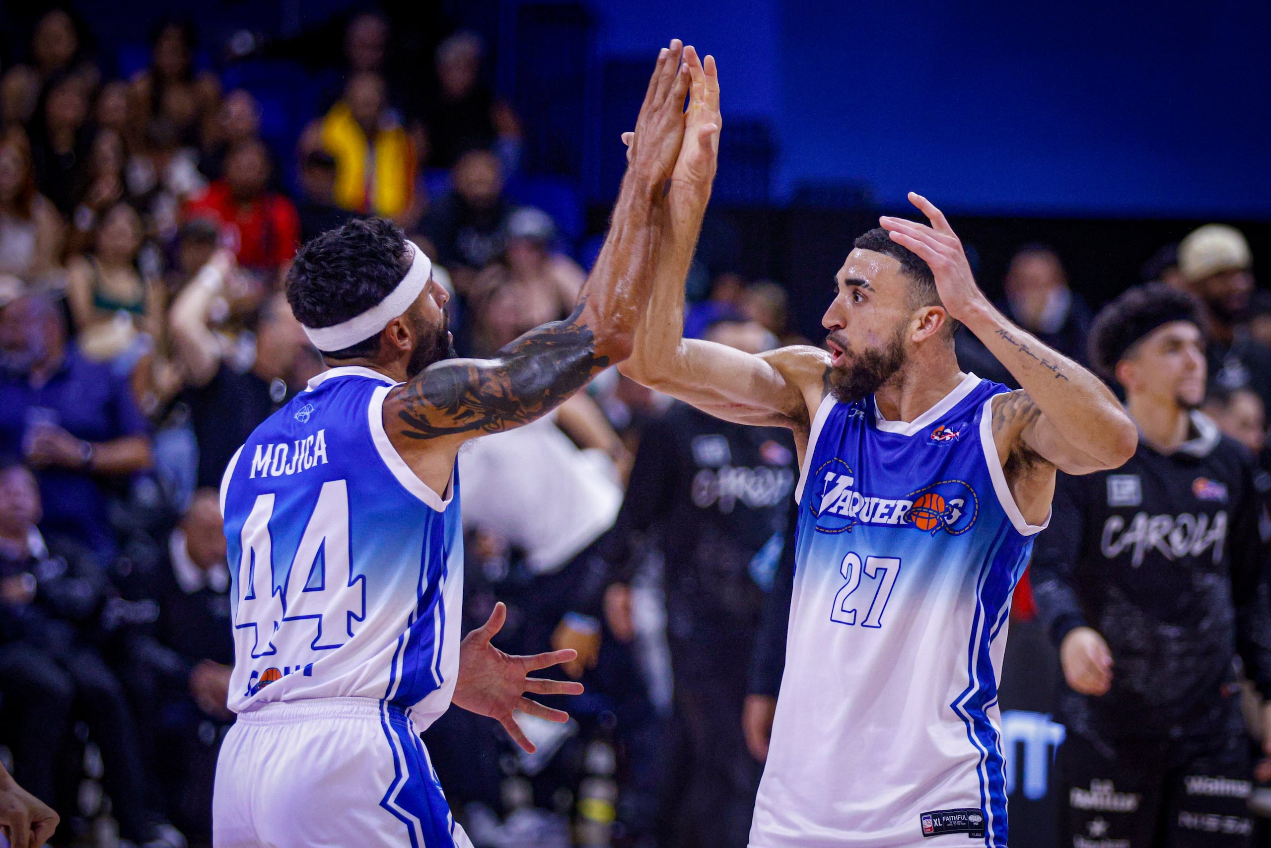 Javier Mojica (izquierda) choca manos con Chris Duarte en el partido del lunes frente a los Gigantes.