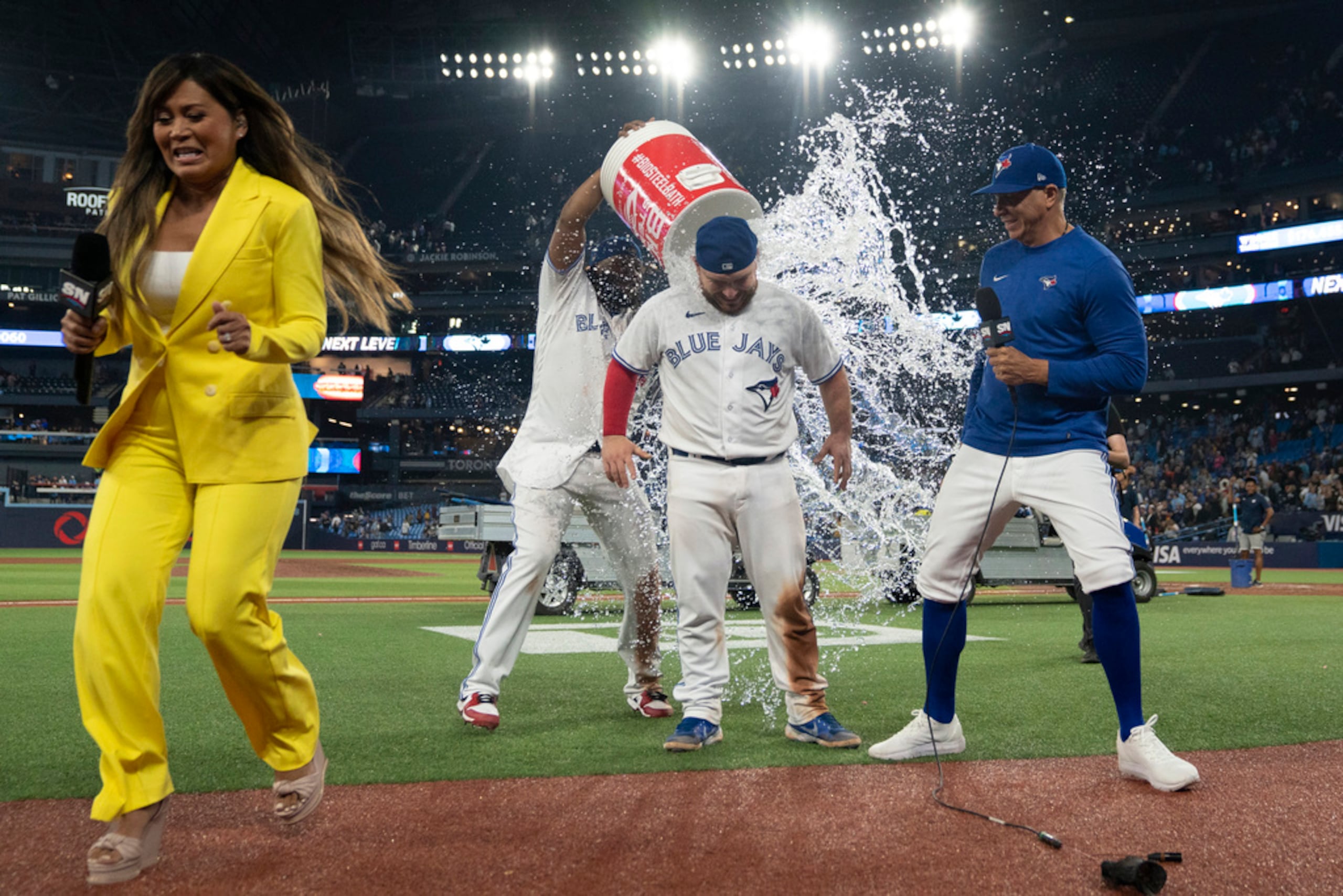 El dominicano Vladimir Guerrero Jr. vacía la hielera encima del mexicano Alejandro Kirk, para festejar la victoria de los Blue Jays.