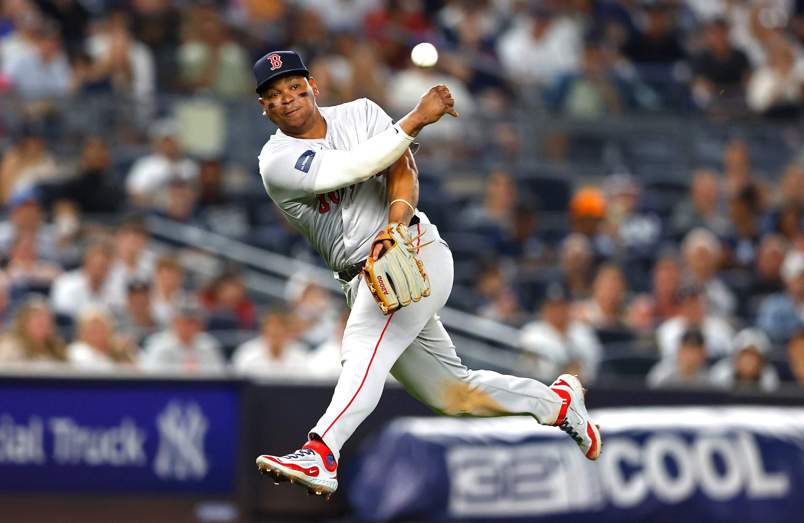 El tercera base dominicano de los Red Sox de Boston, Rafael Devers, lanza para poner fuera en primera base a DJ LeMahieu de los Yankees de Nueva York.