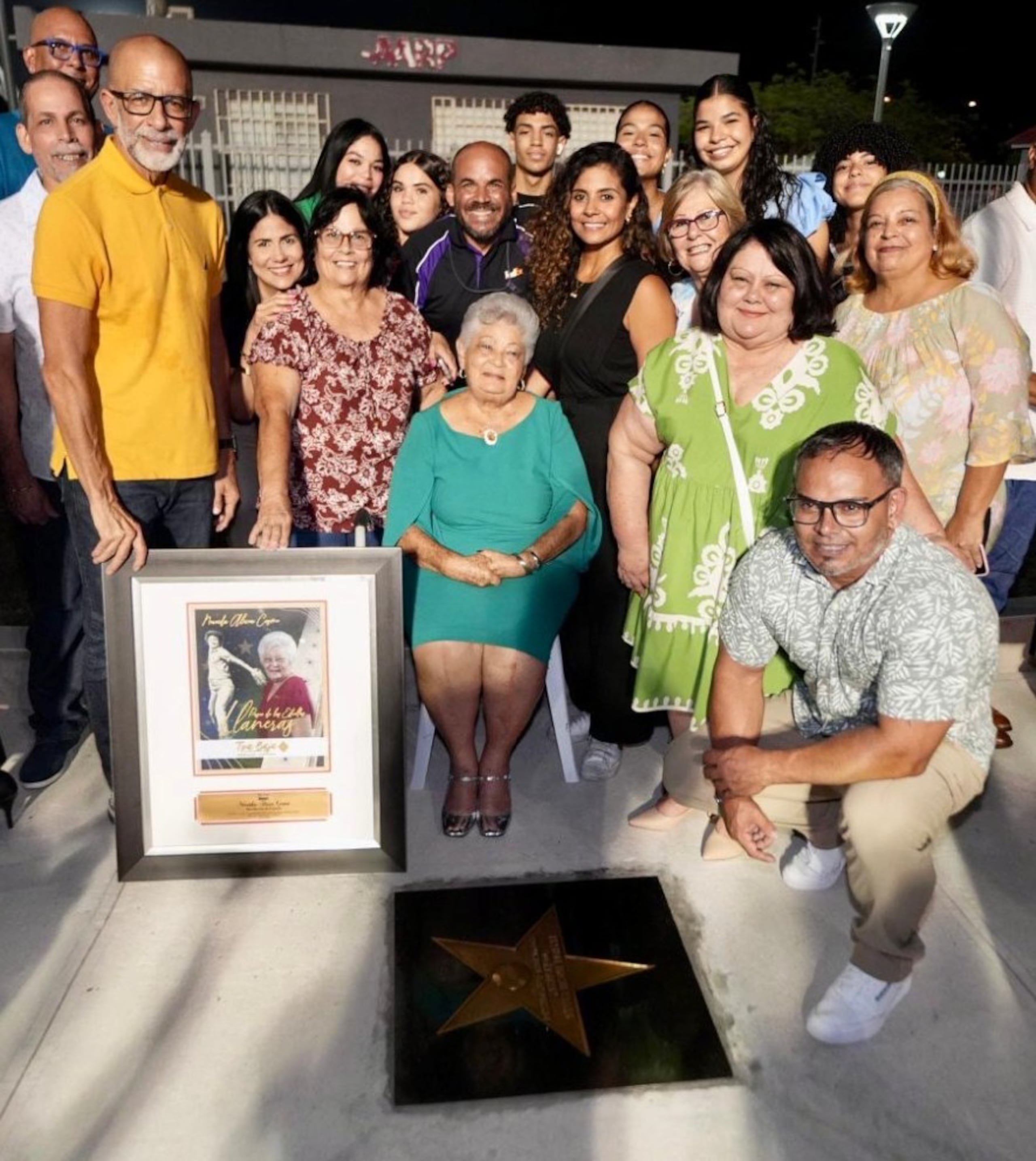 Sentada está Nereida Alicea Cosme, rodeada de familiares y amigos. Ella fue la primera mujer presidenta de la Coliceba.