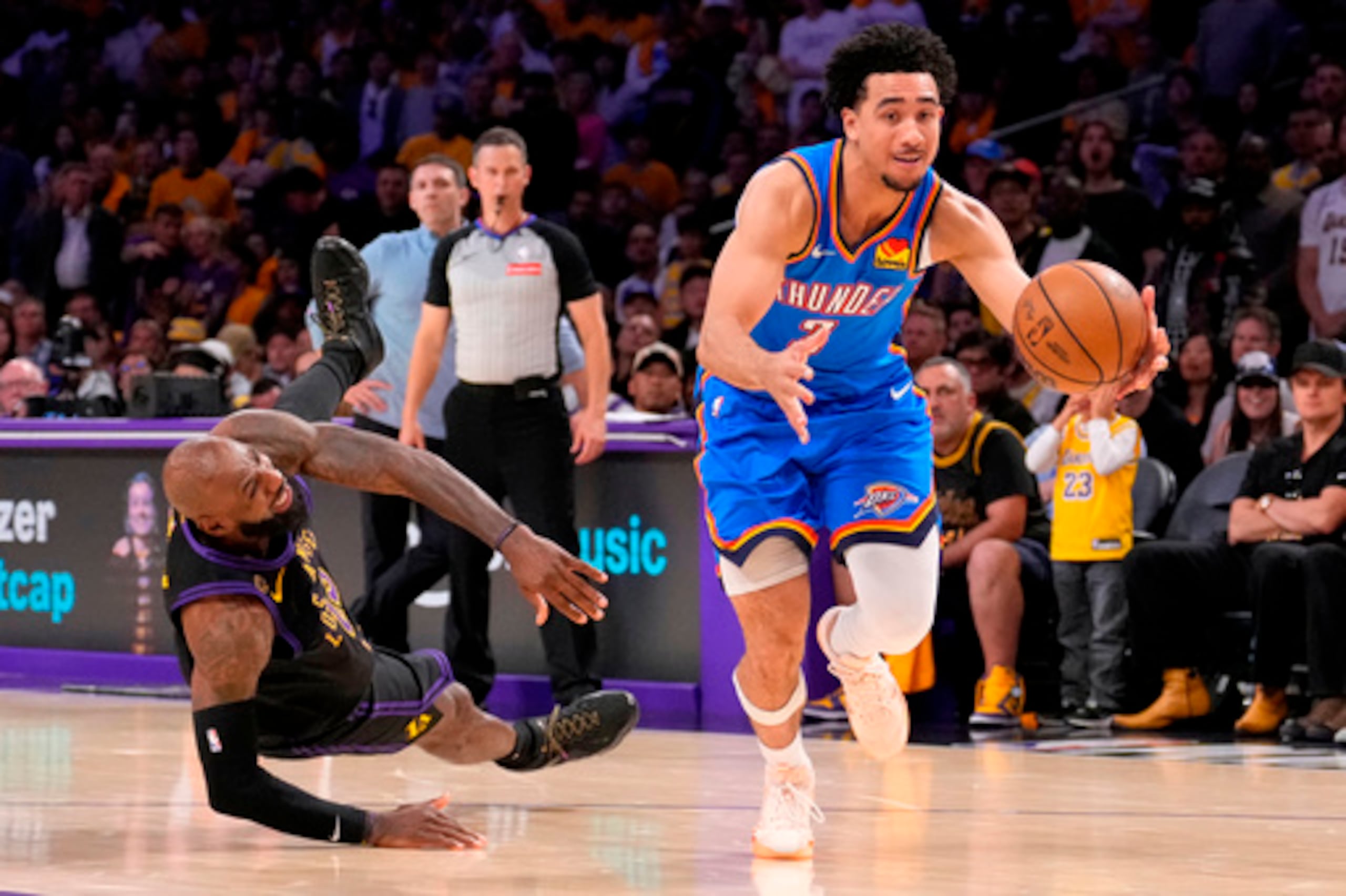El escolta de los Oklahoma City Thunder Jared McCain, a la derecha, conduce hacia la canasta ante la caída del alero de Los Ángeles Lakers LeBron James durante la segunda mitad del cuarto partido de la segunda ronda de los playoffs de baloncesto de la NBA, el lunes 11 de mayo de 2026, en Los Ángeles. (AP Photo/Mark J. Terrill)