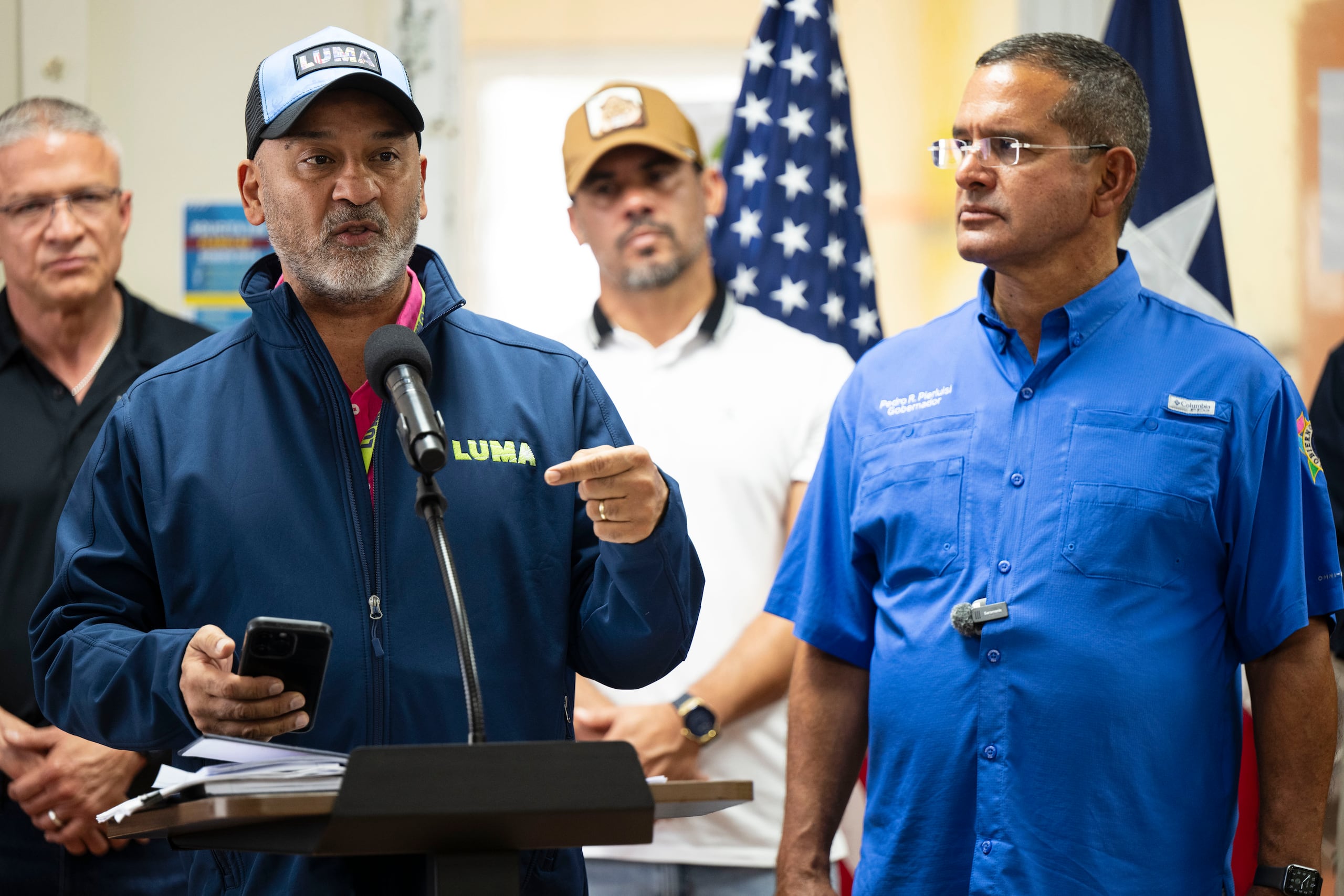 El presidente de LUMA Energy, Juan Saca, precisa el estado del sistema eléctrico tras el paso de la tormenta Ernesto. Lo observa el gobernador Pedro Pierluisi.