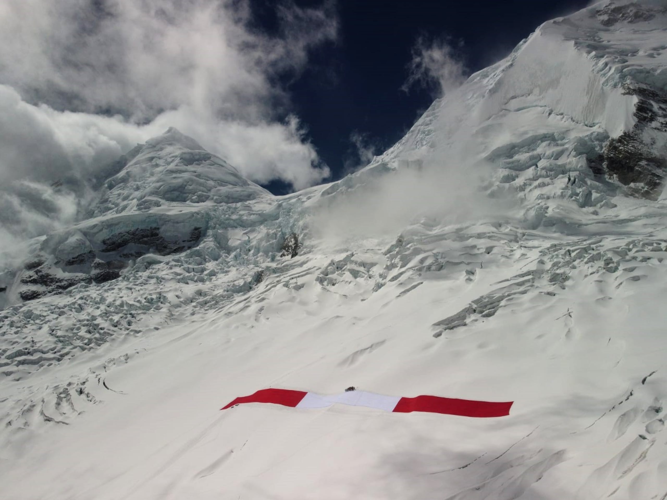 Fotografía fechada el 11 de julio de 2021, cedida por Expedición "Bandera del Bicentenario", que muestra una bandera peruana gigante en la montaña de Huascarán, en Perú.