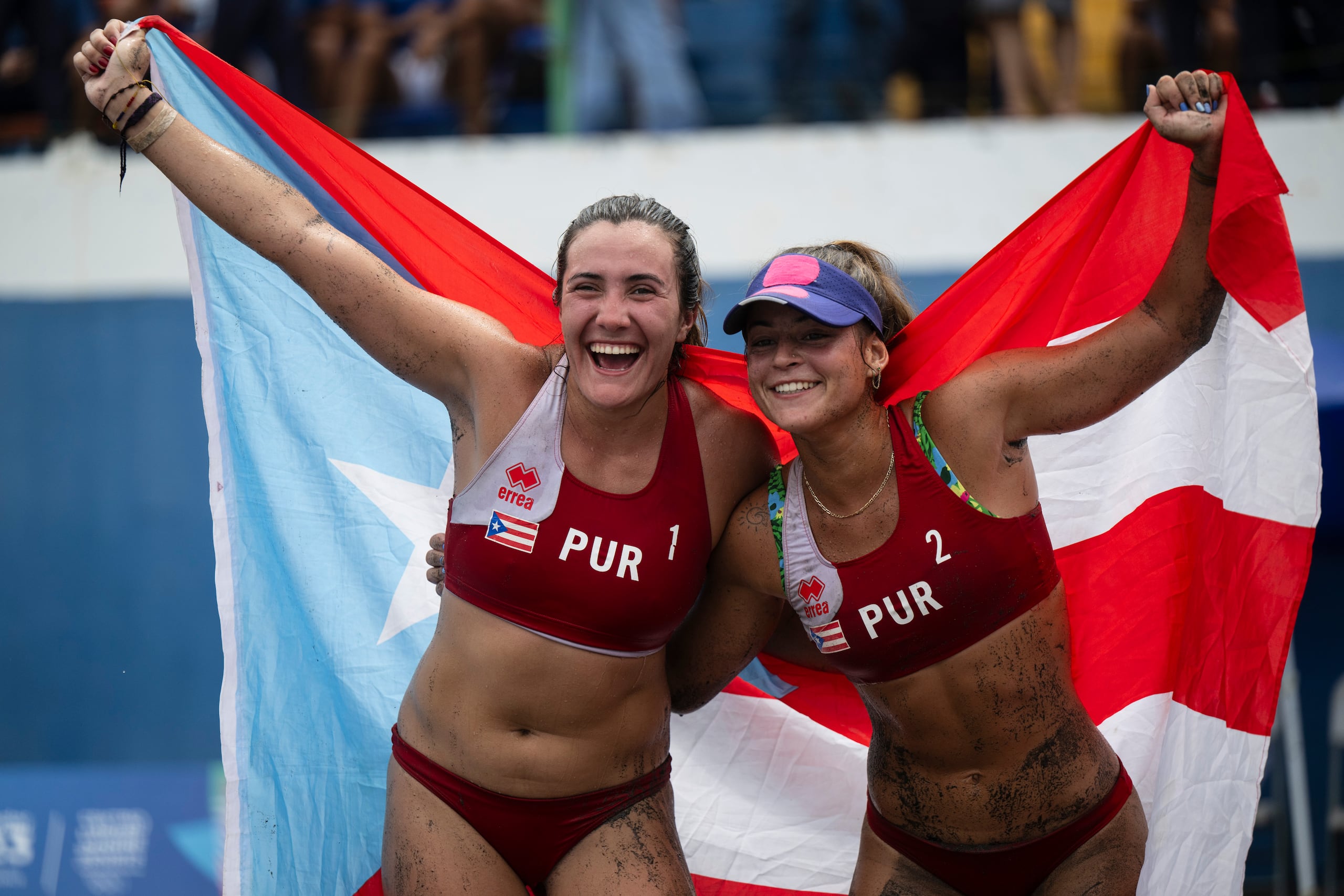 María González y Allanis Navas celebran con la bandera de Puerto Rico.
