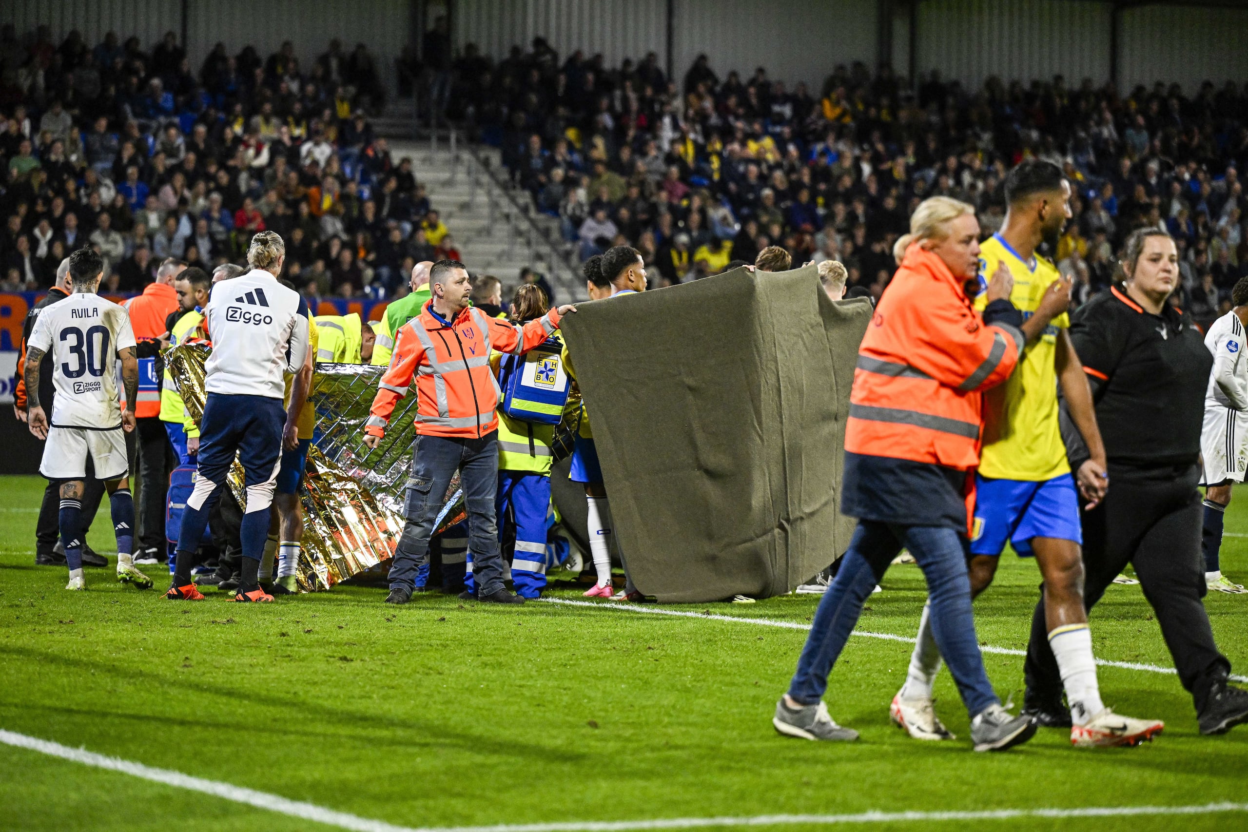 Jugadores y personal, en el momento en el que atendieron al portero Etienne Vaessen sobre el terreno de juego en el partido ante el Ajax.