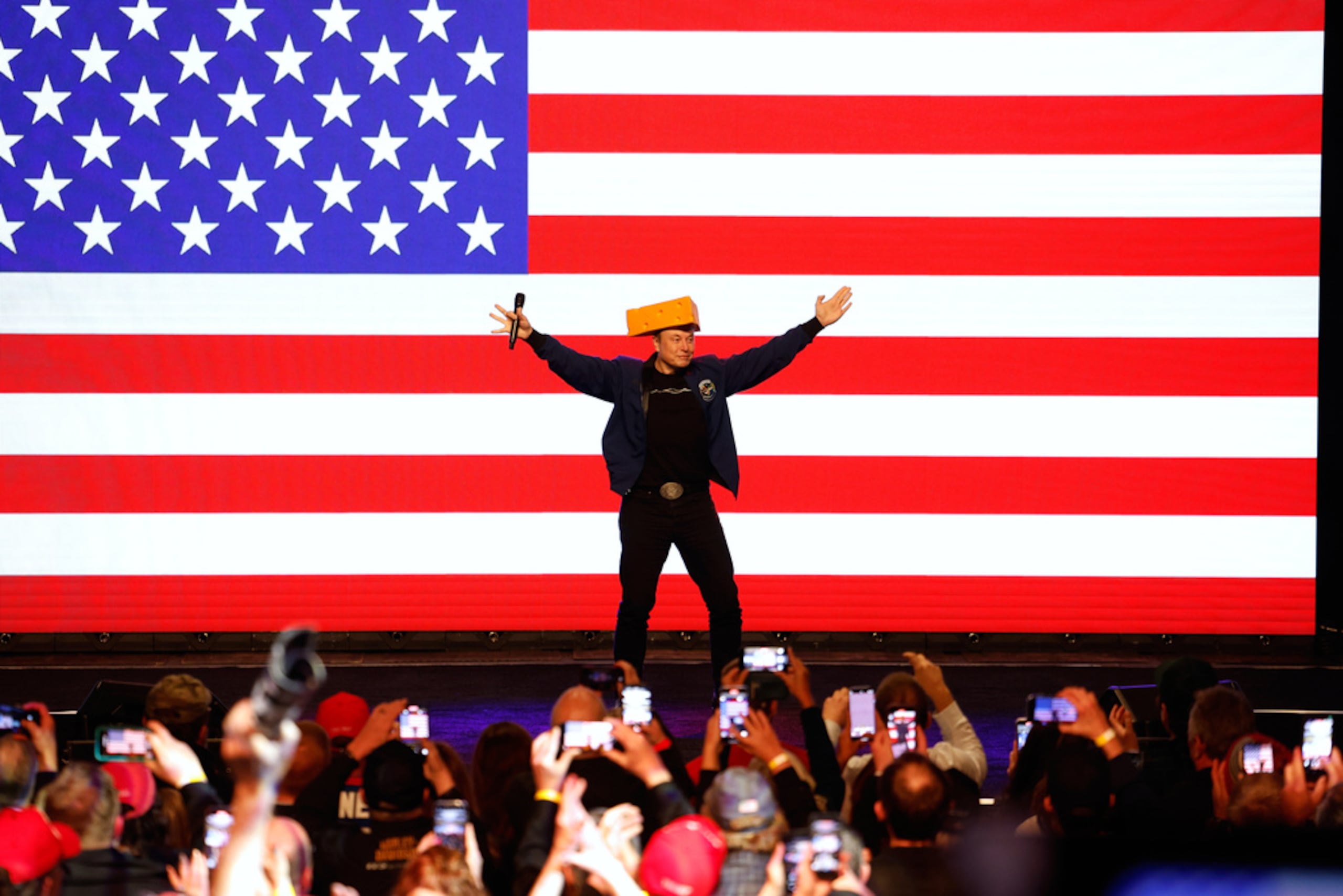 Elon Musk sube al escenario usando una "cheesehead" durante una reunión pública el 30 de marzo de 2025, en Green Bay, Wisconsin.