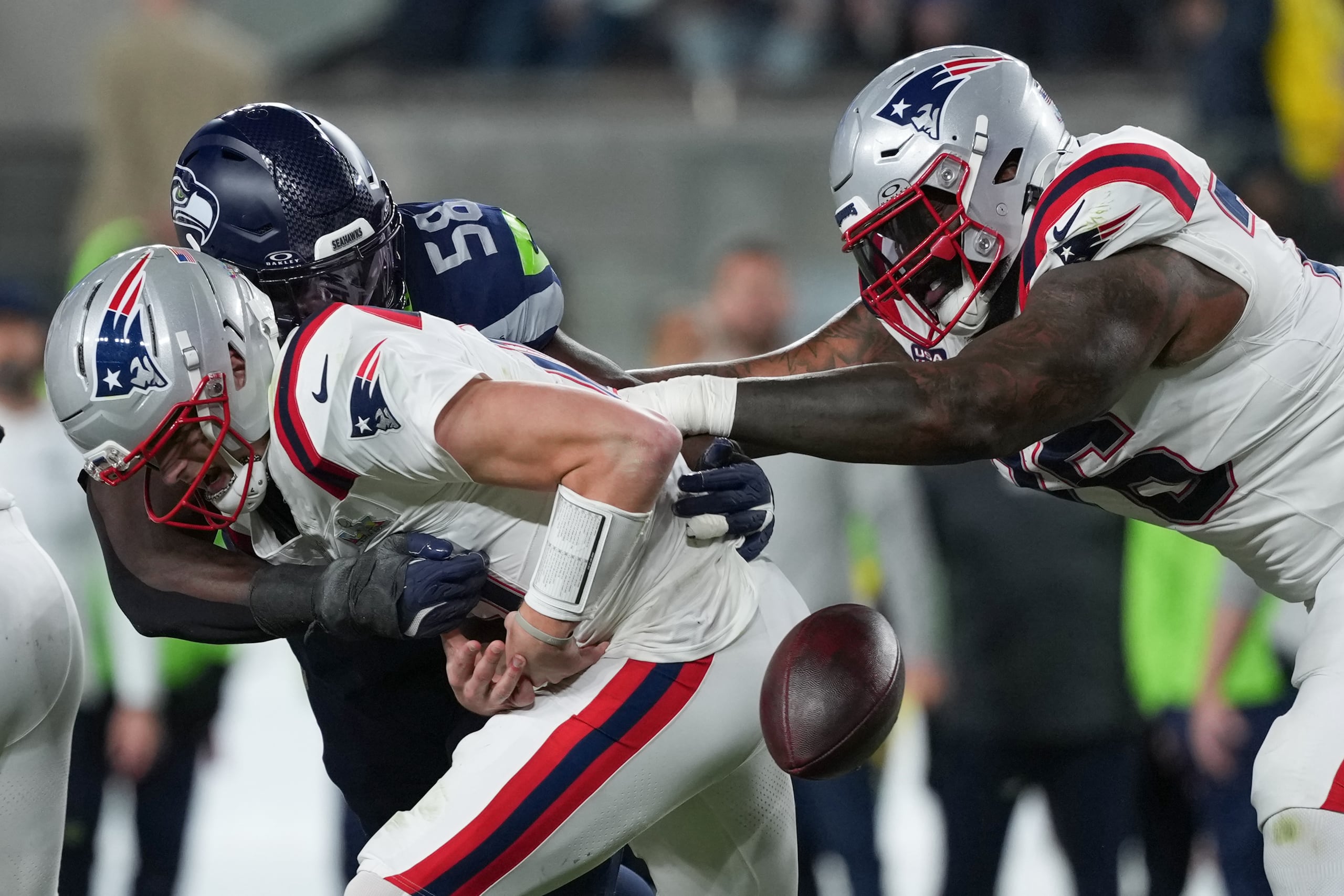 El mariscal de campo de los Patriots, Drake Maye (10), pierde el balón mientras es capturado por el linebacker de los Seahawks, Derick Hall (58).