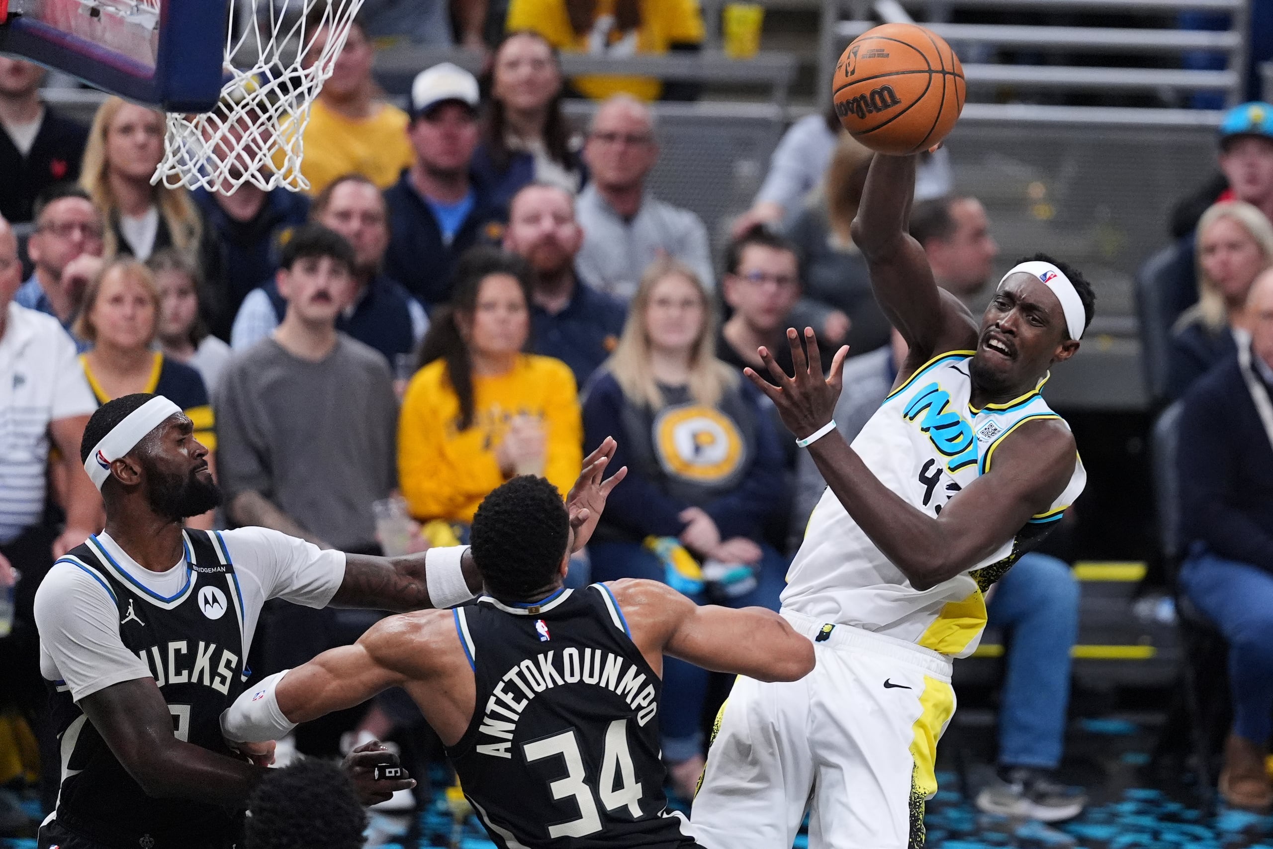 Pascal Siakam, de los Pacers de Indiana, envía un pase frente a Giannnis Antetokounpo, de los Bucks de Milwaukee, durante el partido de playoffs disputado el martes 22 de abril de 2025 (AP Foto/Michael Conroy)