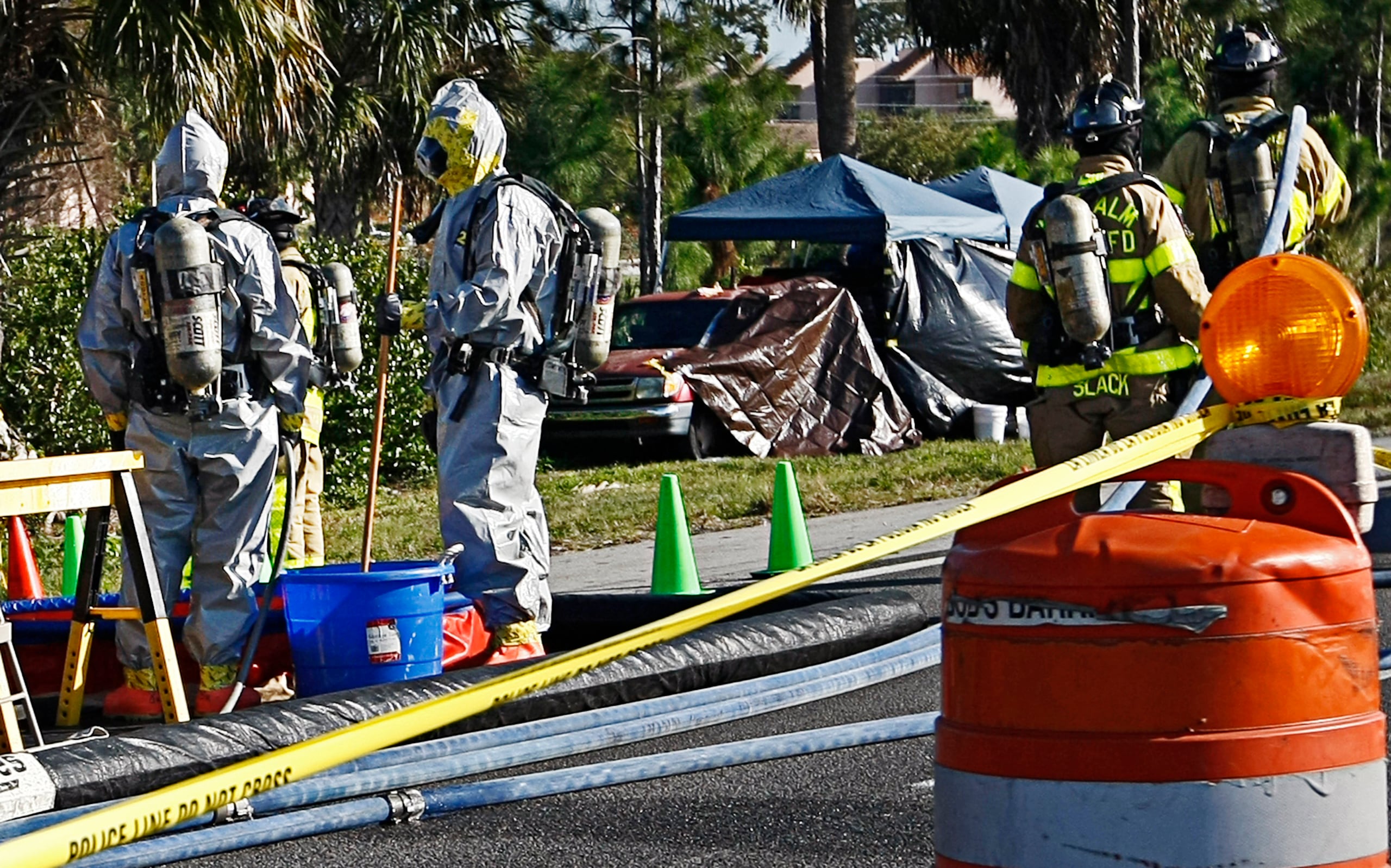 En esta foto del 15 de febrero de 2011, bomberos del condado de Palm Beach con trajes de protección trabajan cerca del camión de pesticidas de Jorge Barahona, al costado de la autopista interestatal 95, cerca de West Palm Beach, Florida. El cuerpo gravemente deteriorado de la hija adoptiva de 10 años fue descubierto en el camión horas después de que su hermano gemelo, gravemente herido, fuera hallado en el asiento delantero sufriendo convulsiones, tras haber sido rociado con ácido. Barahona estaba tirado en el suelo cerca del camión con quemaduras severas, aparentemente provocadas por gasolina que él mismo se había echado.